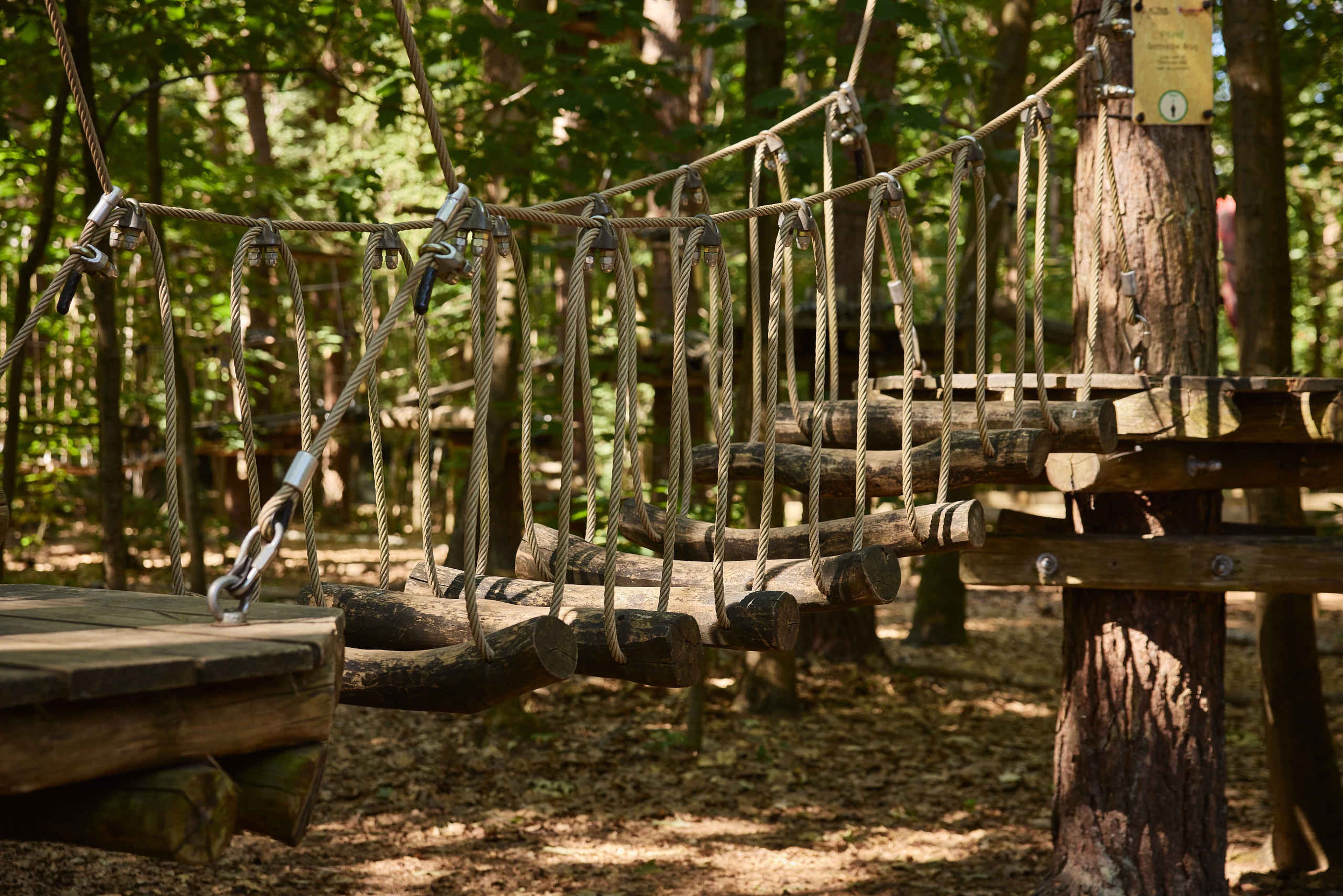 Een brug met slingerende balken op route 6 van het Pico Parcours bij Klimrijk Brabant