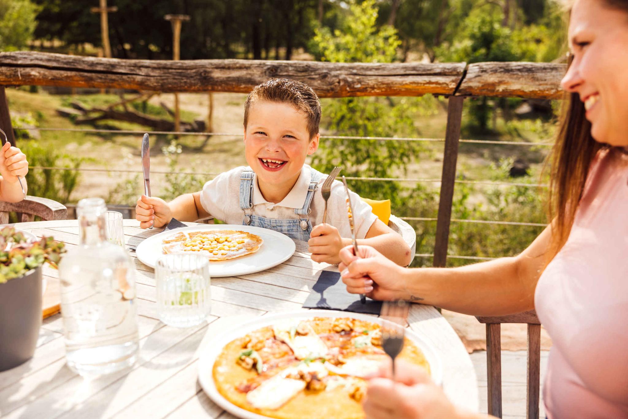 Terras Wanyama een jongen en moeder eten pannenkoeken in Safaripark Beekse Bergen
