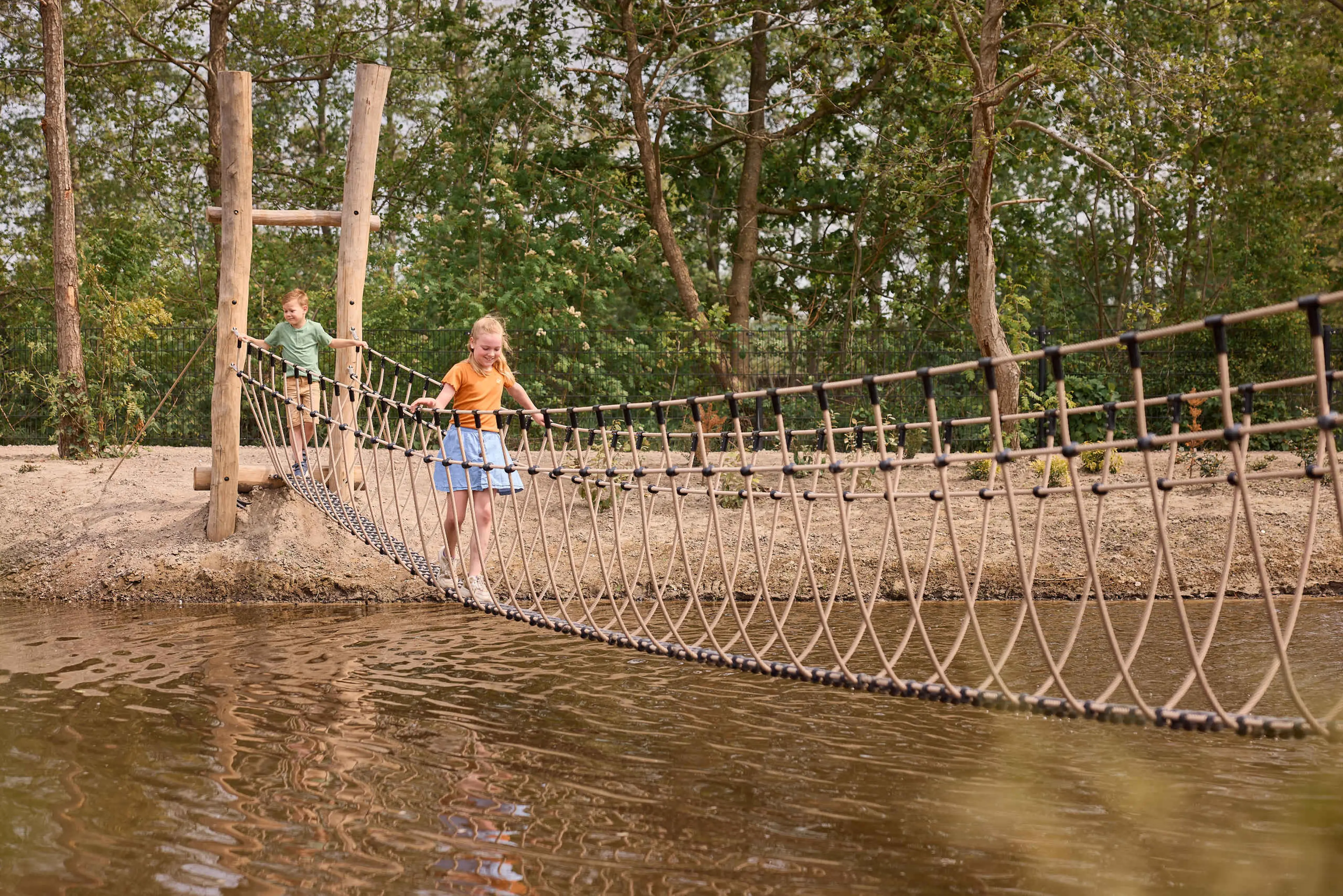 Jongen en meisje klimmen over water op een brug AquaZoo Leeuwarden