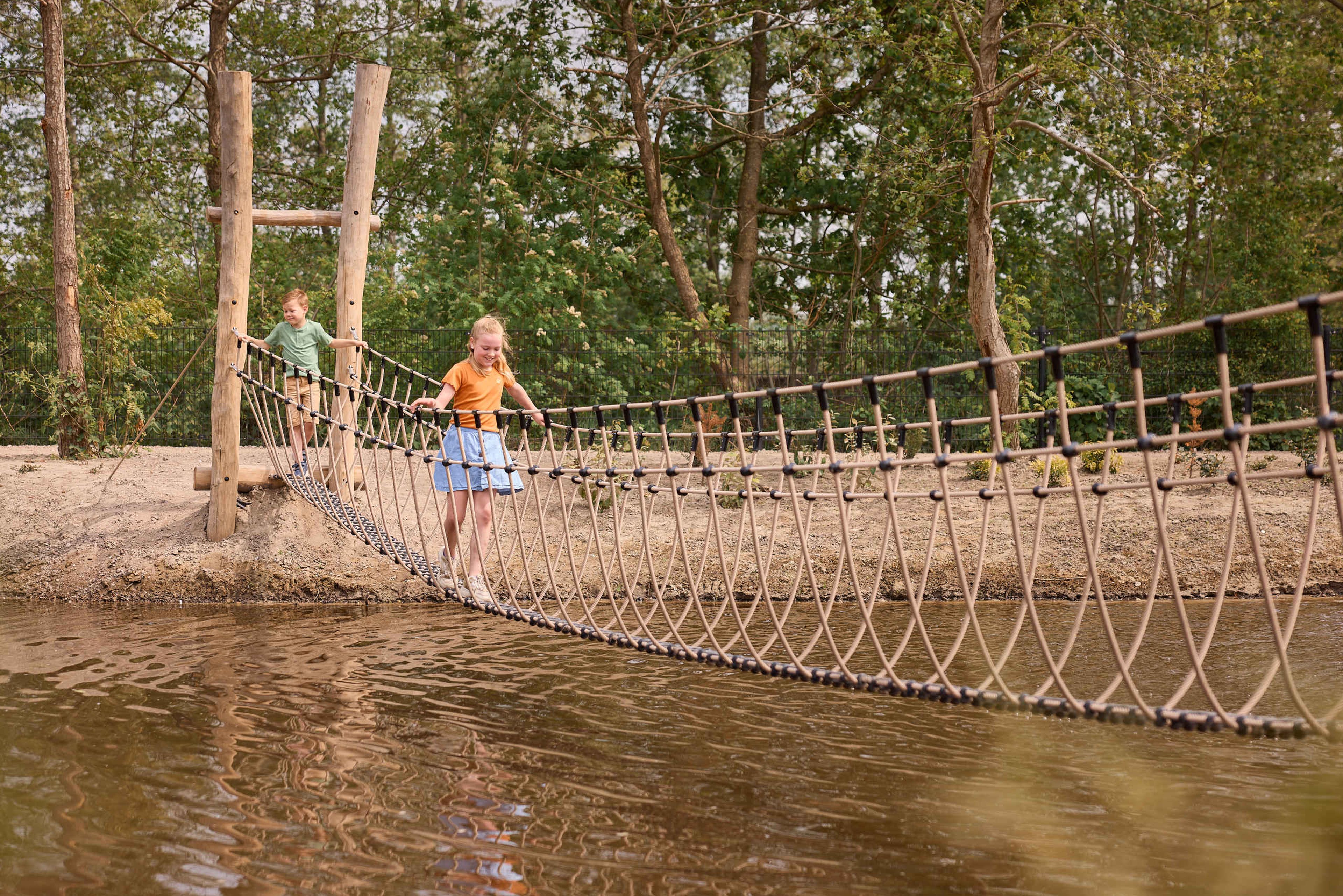 Jongen en meisje klimmen over water op een brug AquaZoo Leeuwarden
