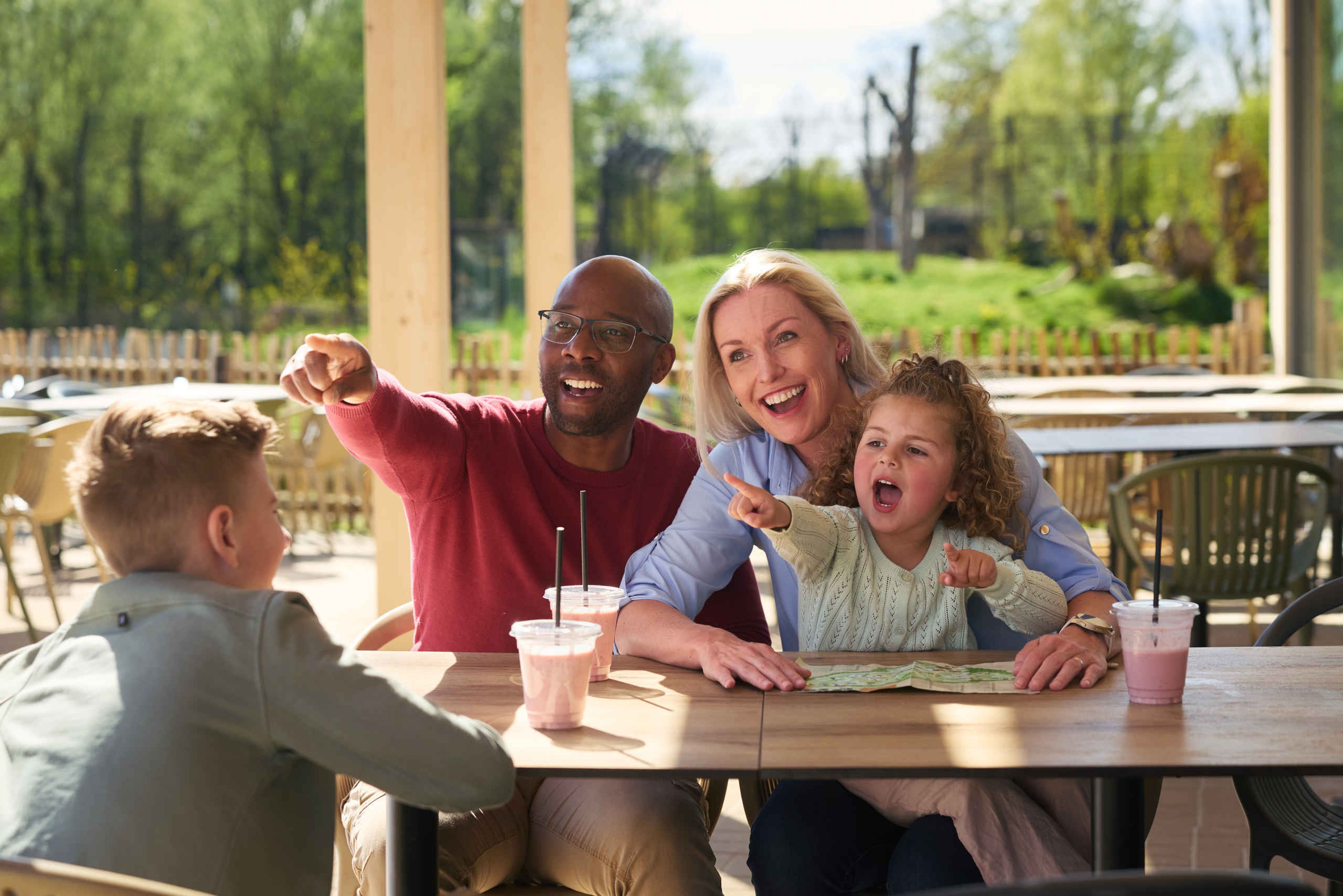 Een gezin drinkt buiten op het terras hun smoothies bij Restaurant de Waterplaats in Eindhoven Zoo.
