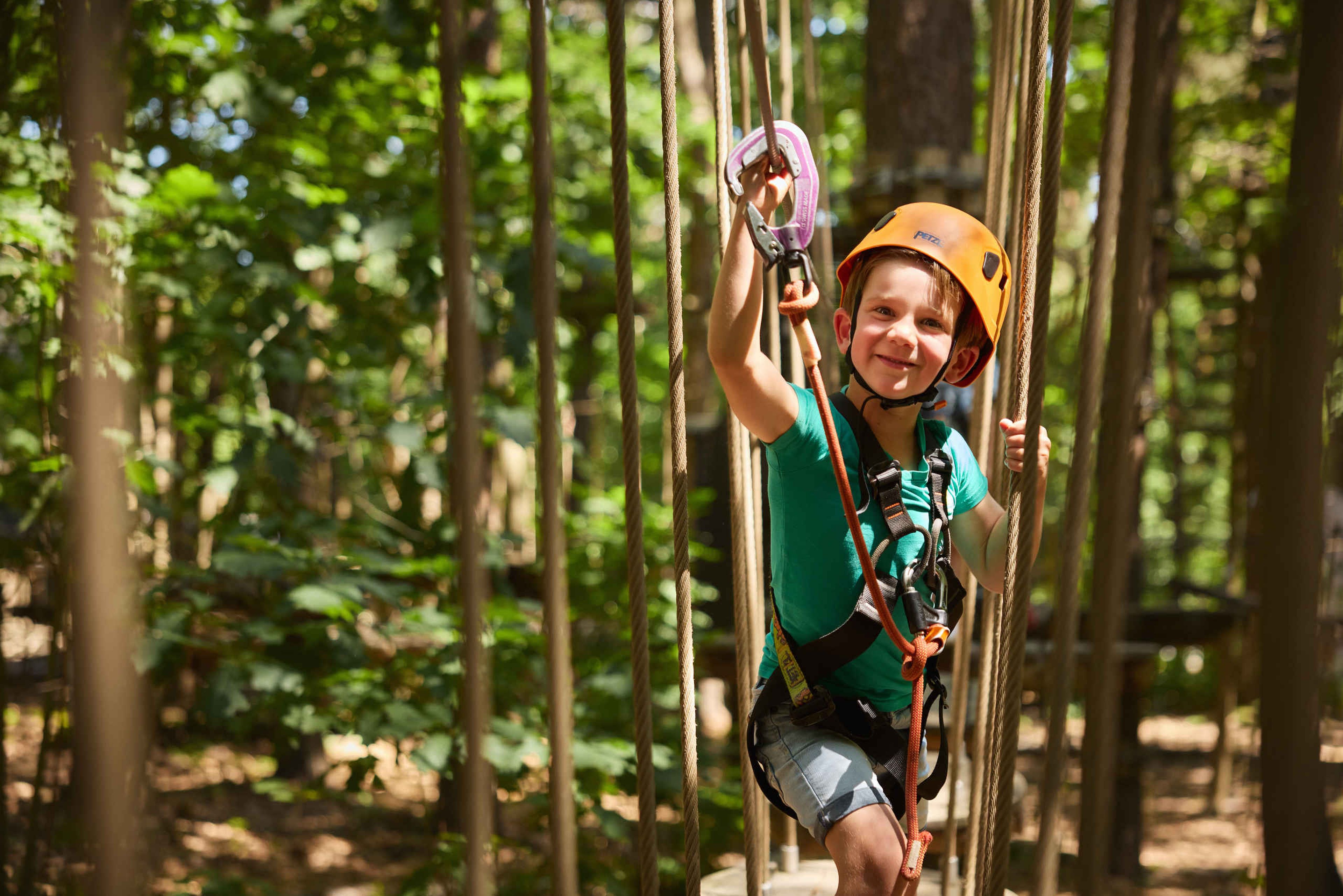 Een jongetje met zijn zekering op het Pico Parcours van Klimrijk Brabant