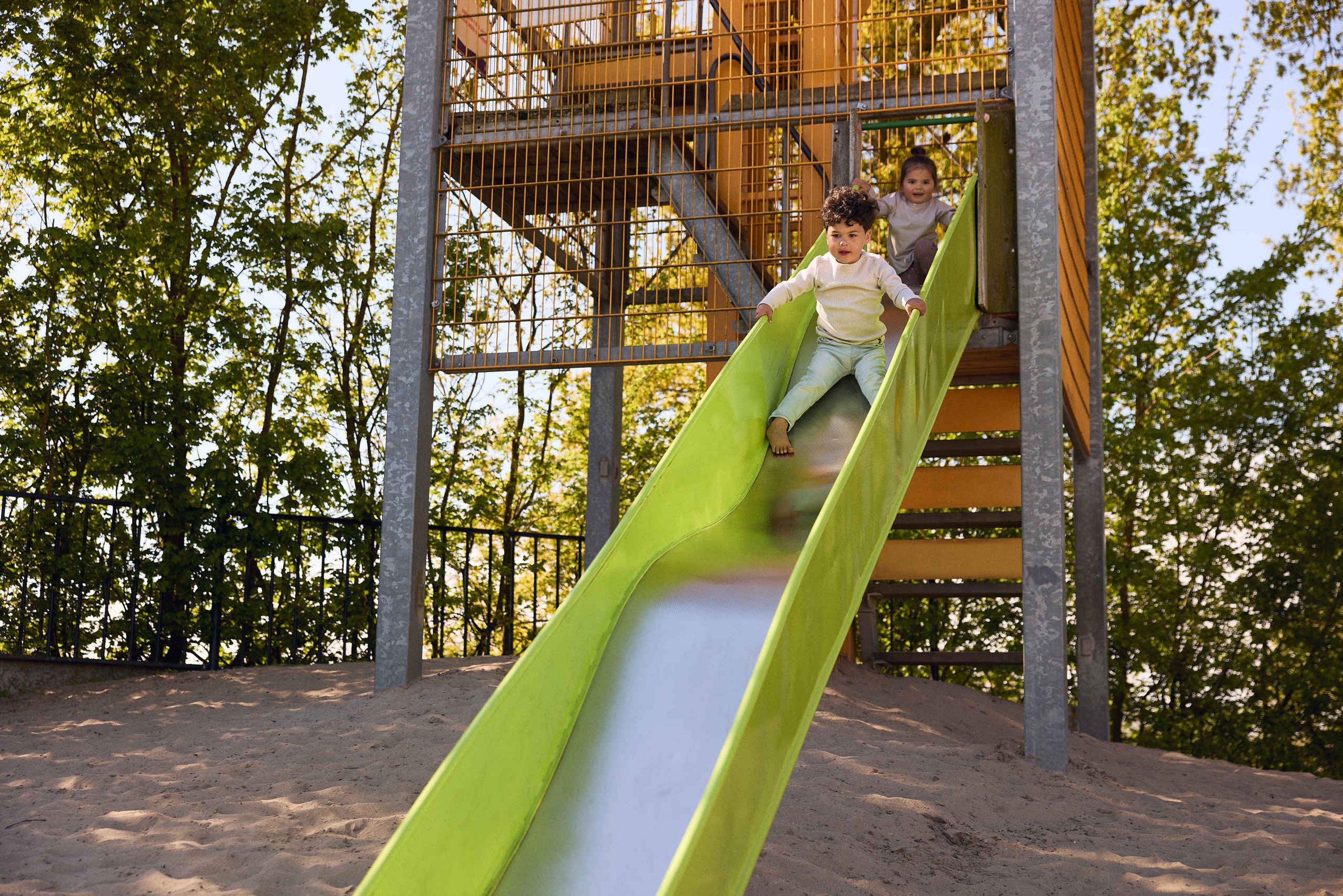 Twee kinderen gaan van de glijbaan in een speeltuin in Eindhoven Zoo