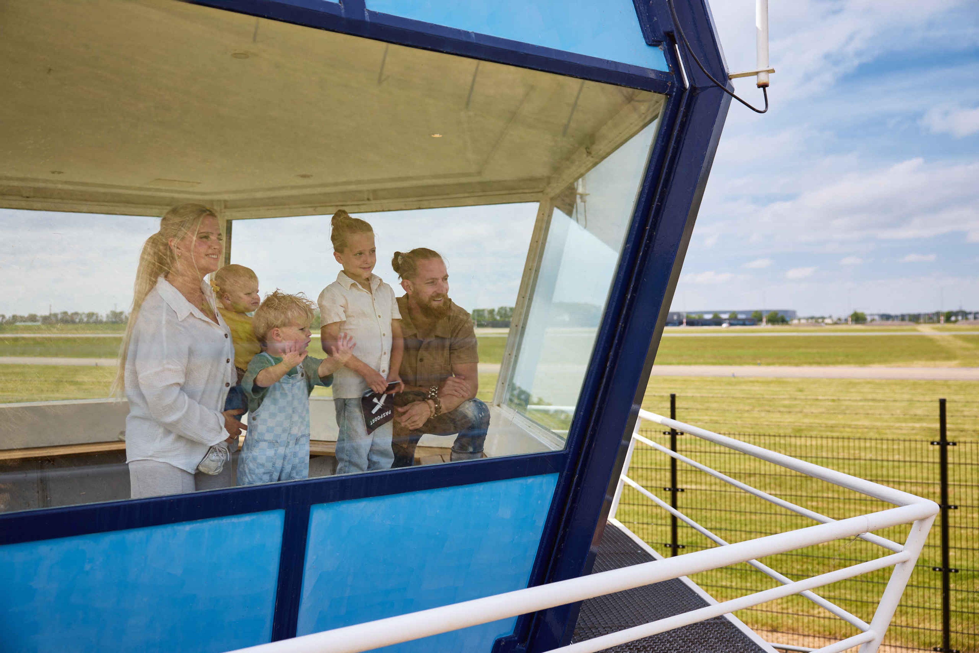 Een gezin in de verkeerstoren met uitzicht op de landingsbaan bij Luchtvaartmuseum Aviodrome
