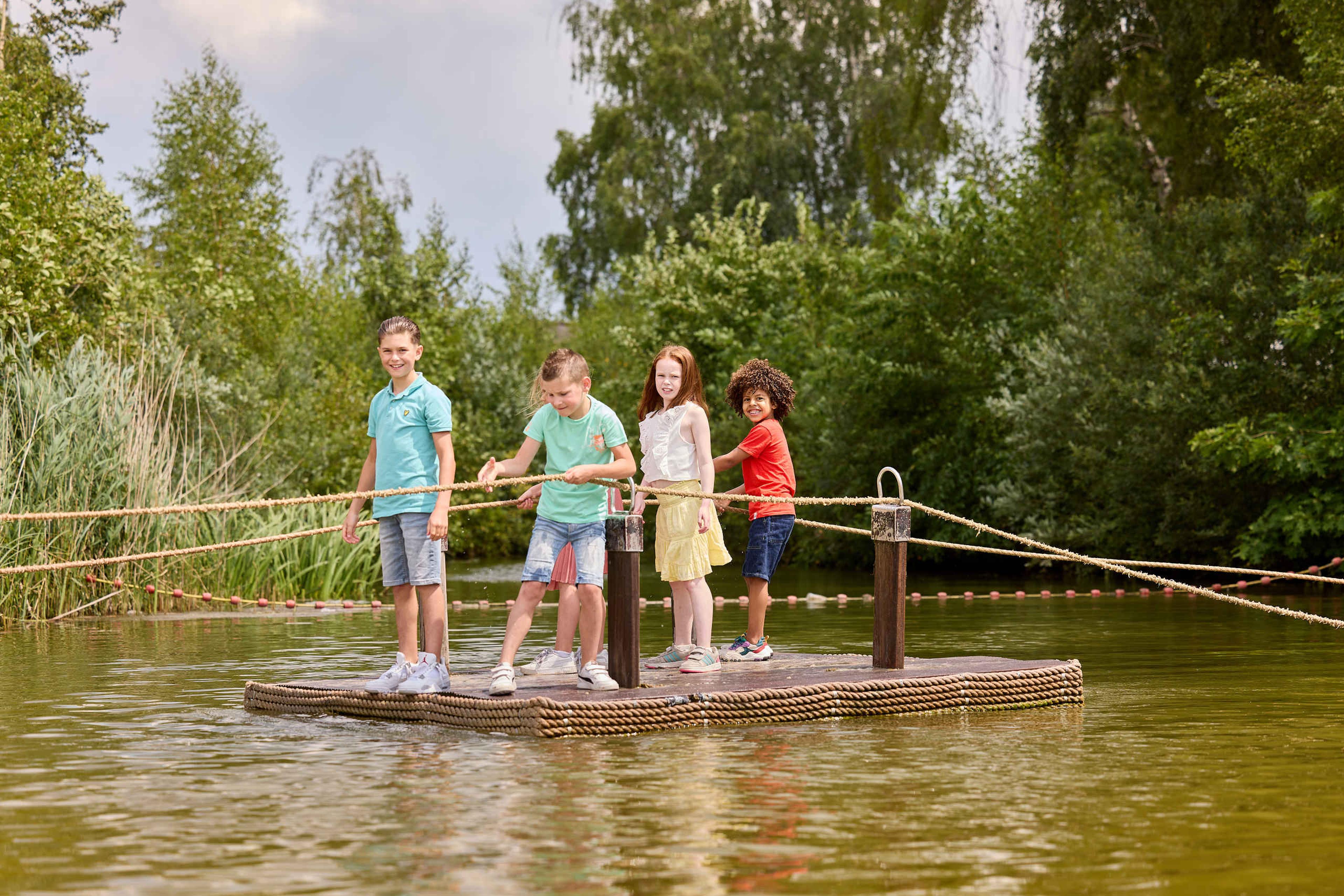 Kinderen op een vlot bij het avontureneiland van Speelland Beekse Bergen