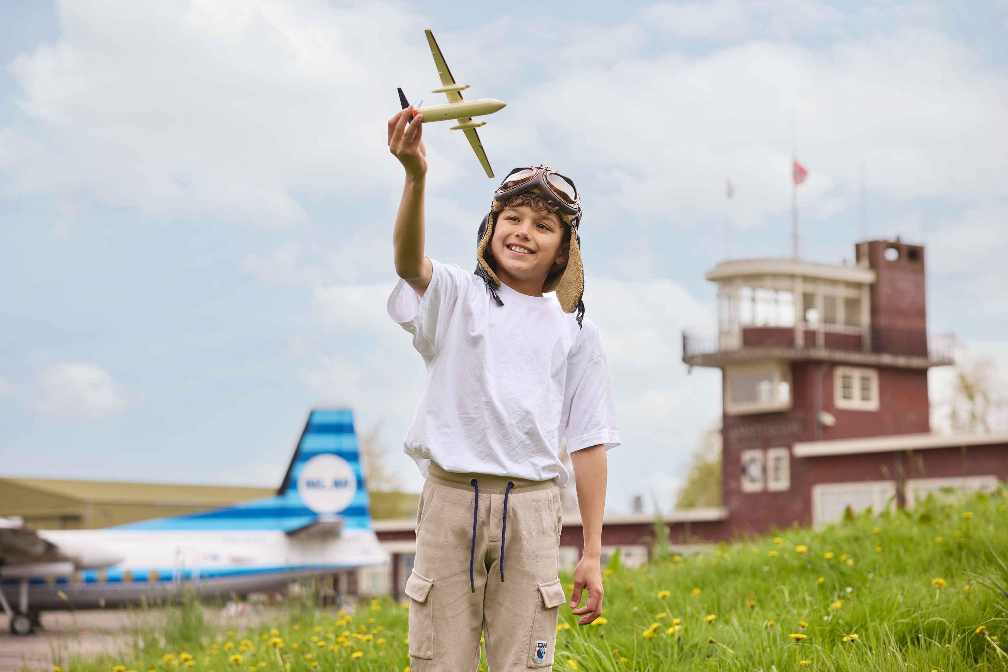 Jongen met modelvliegtuig kind met pilotenmuts Luchtvaartmuseum Aviodrome