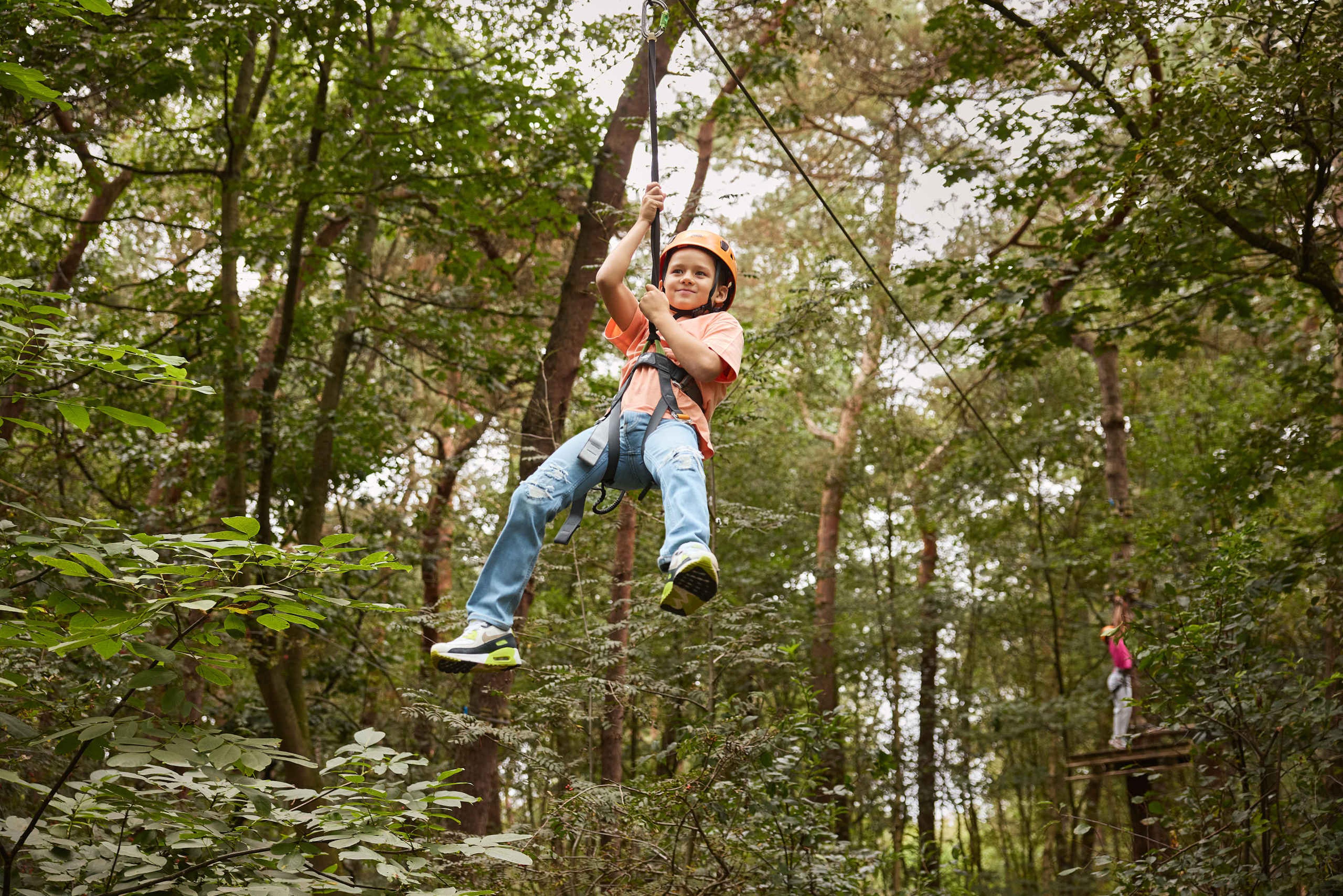 Een jongen op de zipline van route 3 op het Klimparcours bij Klimrijk Brabant