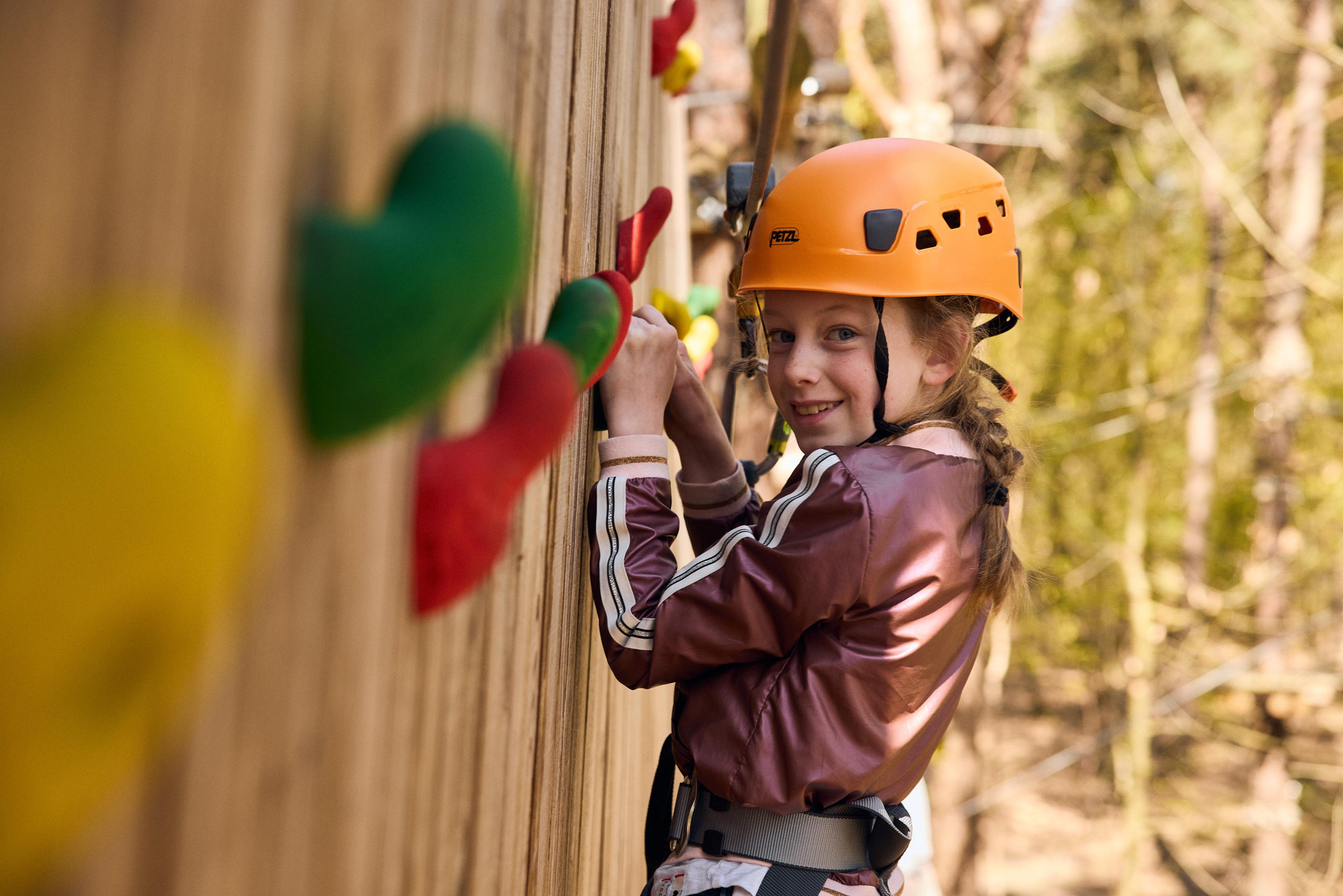 Meisje aan het klimmen op de klimwand van het klimparcours van Klimrijk Brabant