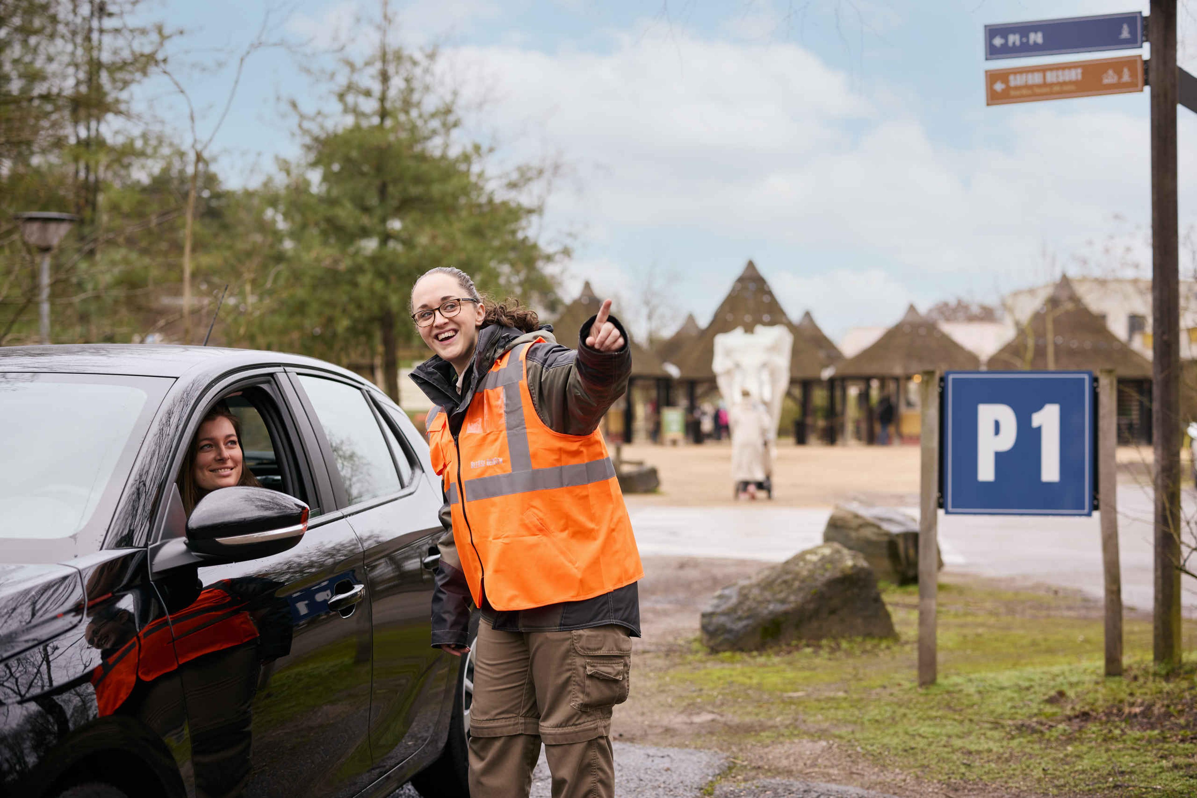 Medewerker wijst de route voor auto in Safaripark Beekse Bergen