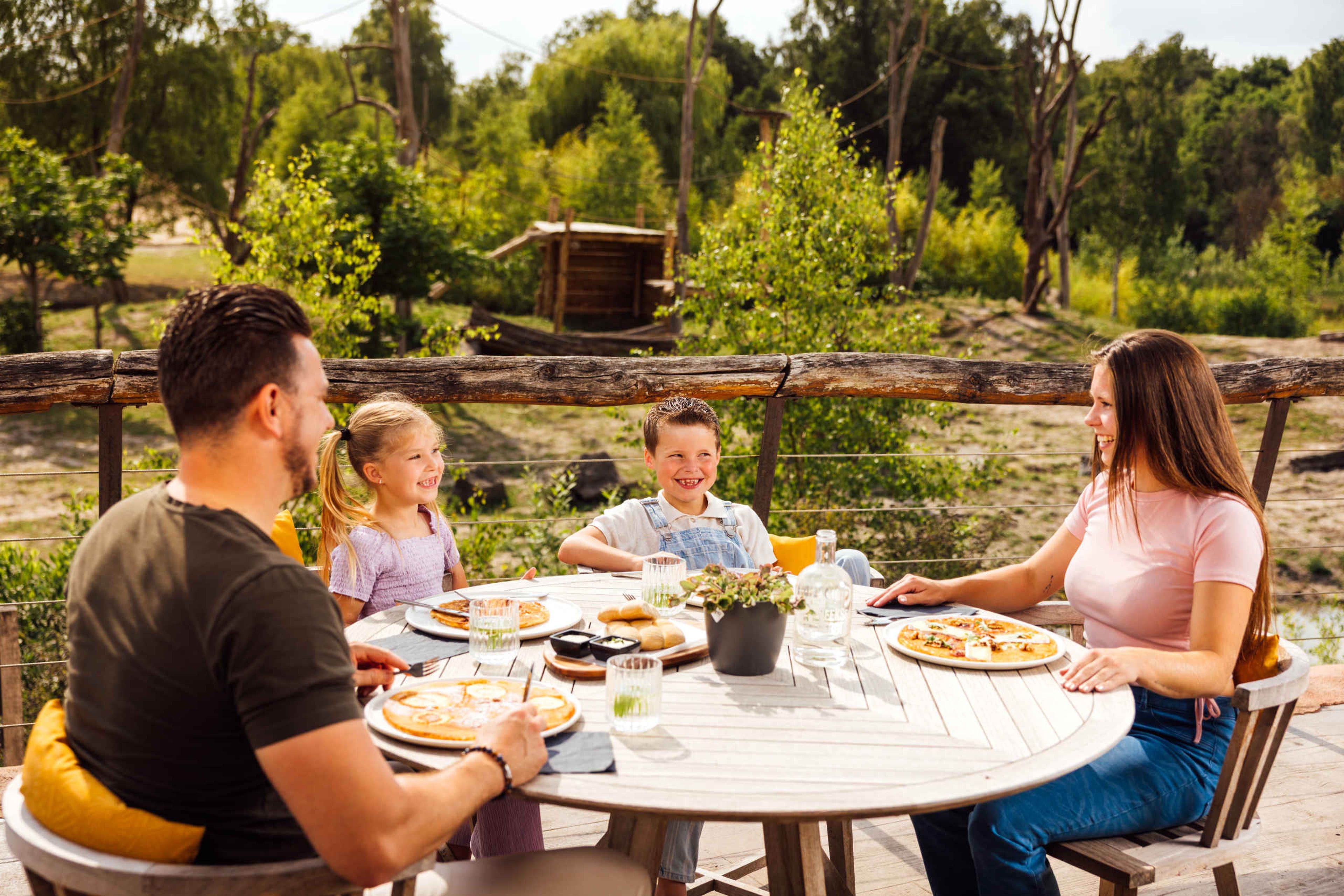 Kinderen met ouders op het terras van Wanyama eten pannenkoeken in Safaripark Beekse Bergen