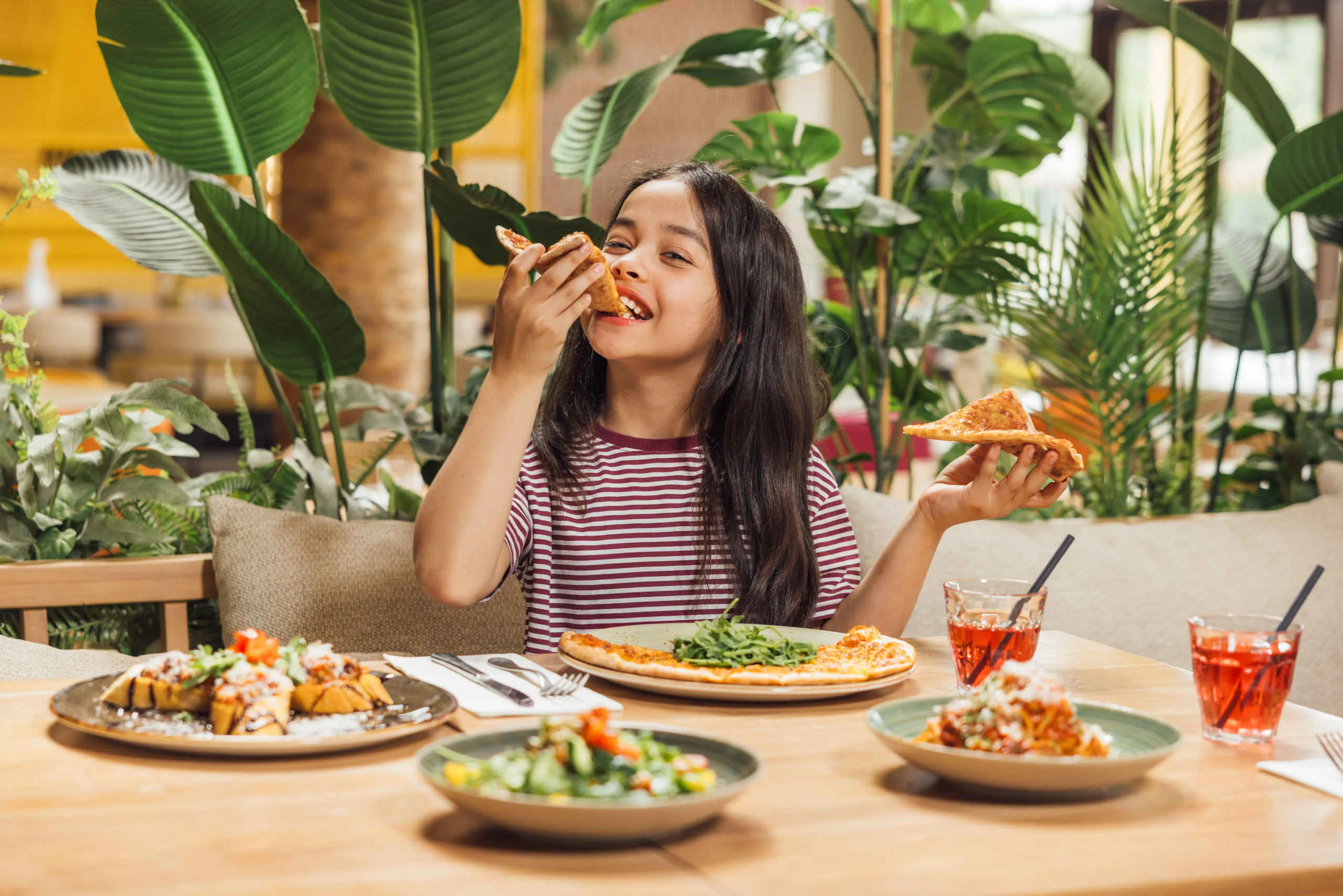 Meisje eet een pizza in restaurant Labadi op Lake Resort Beekse Bergen