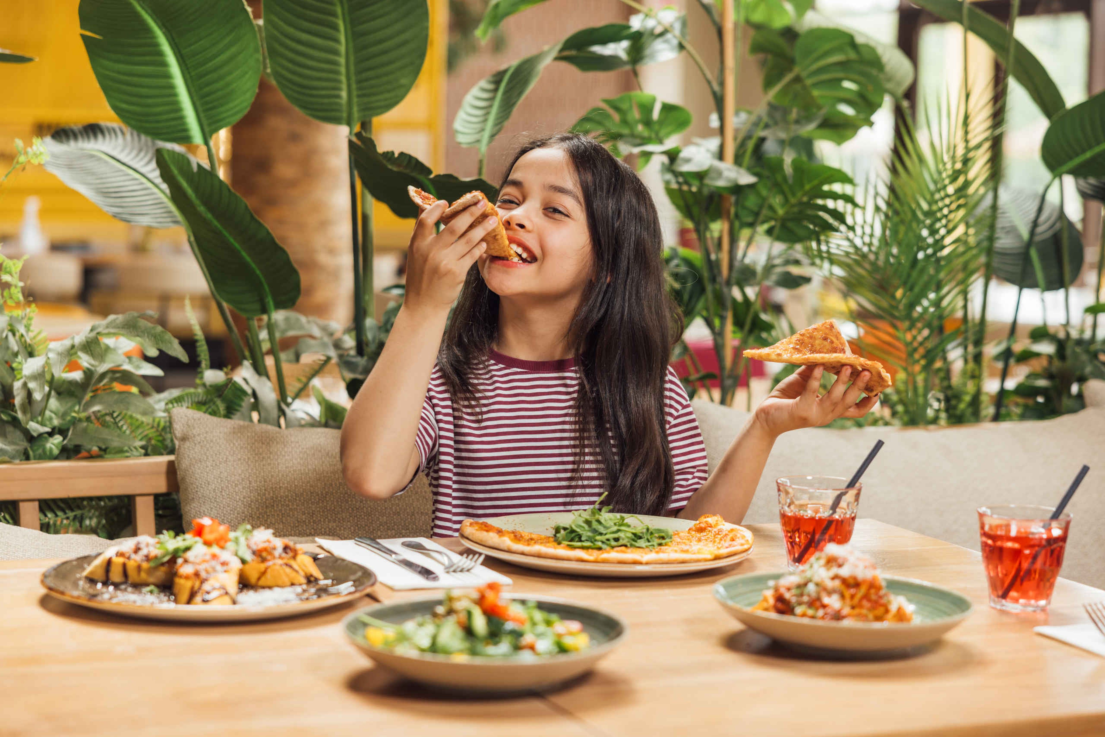 Meisje eet een pizza in restaurant Labadi op Lake Resort Beekse Bergen