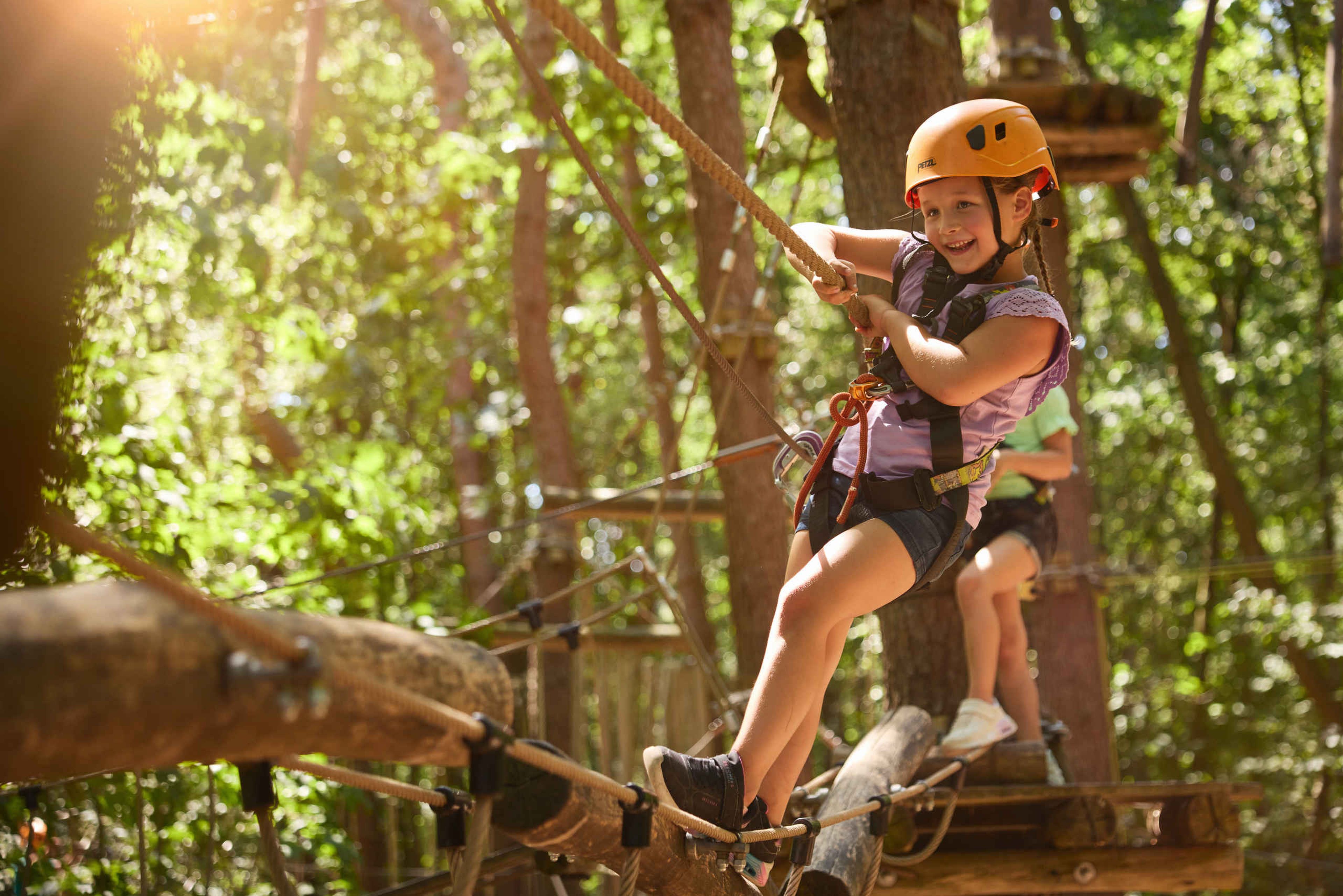 Twee meisjes balanceren op de balken-brug van het Pico Parcours bij Klimrijk Brabant