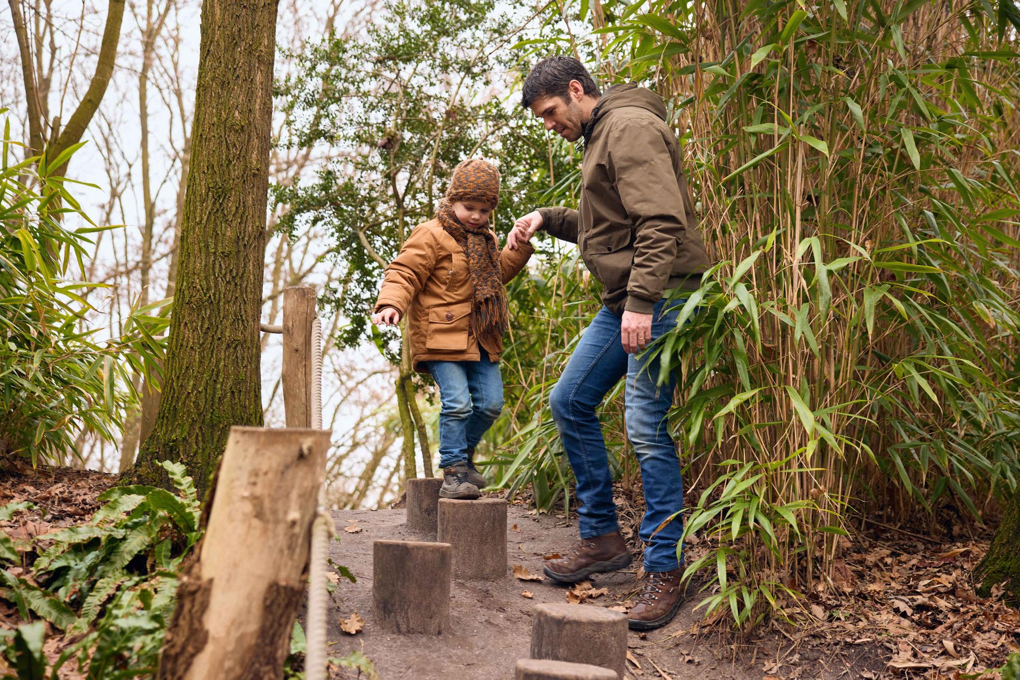 Een vader en zoon lopen over de avonturenpaadjes van ZooParc Overloon