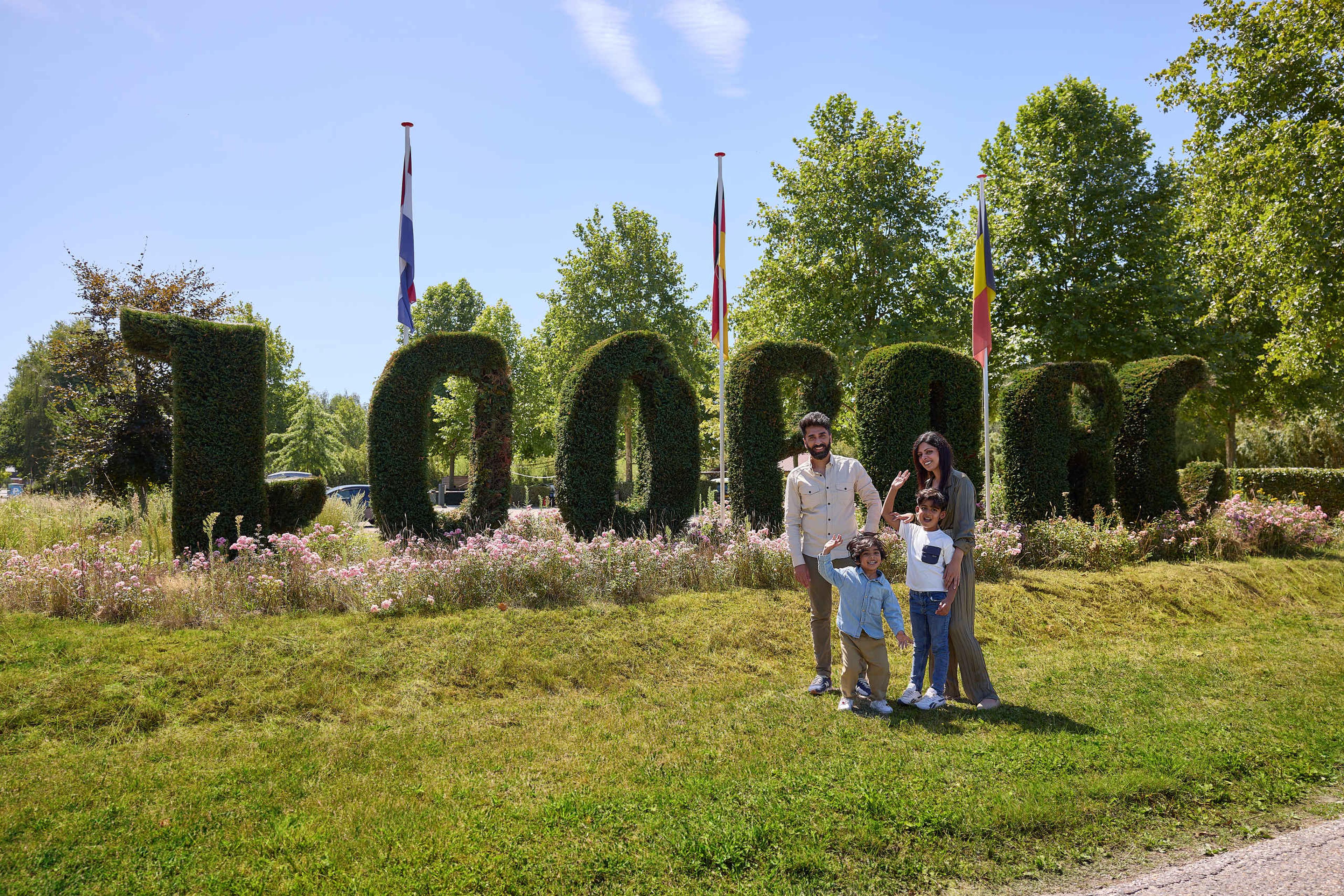 Een gezin staat voor de ingang van ZooParc Overloon.