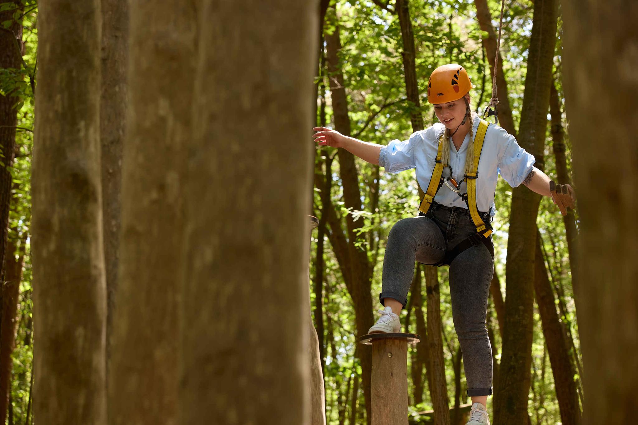 Een meisje klimt op palen bij Expeditie Klimrijk bij Klimrijk Brabant.
