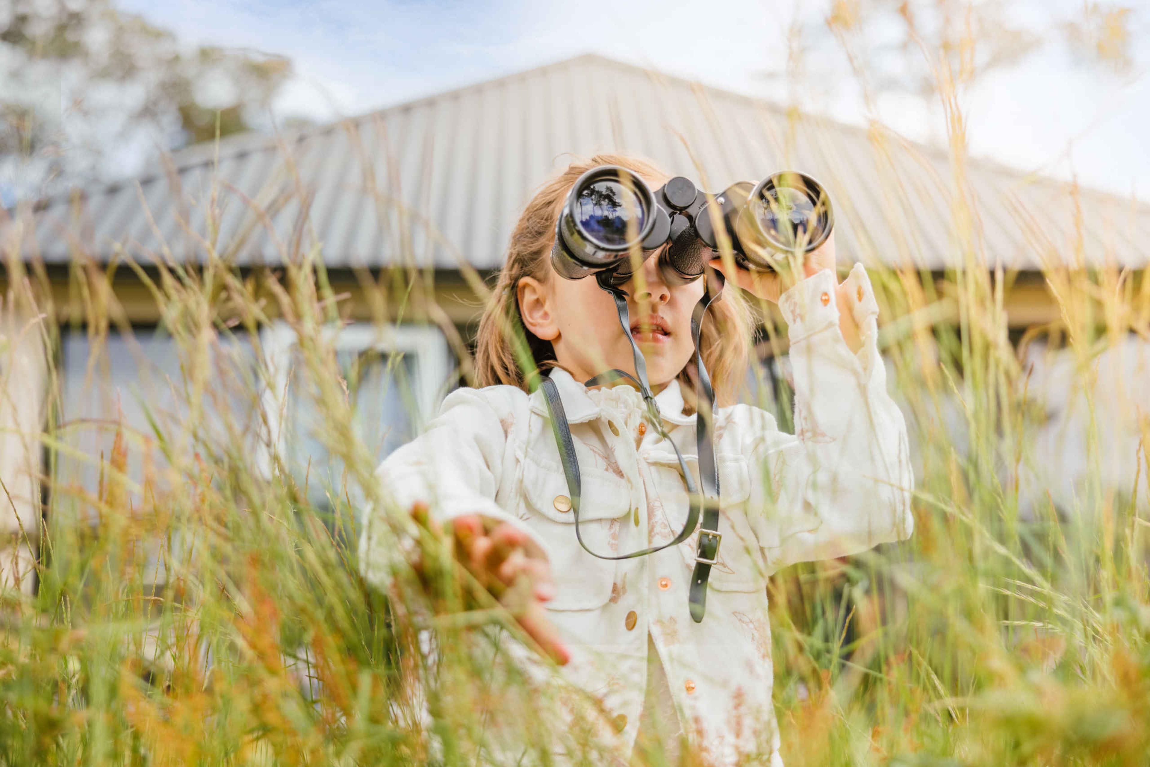 Meisje met verrekijker in het gras op Safari Resort Beekse Bergen