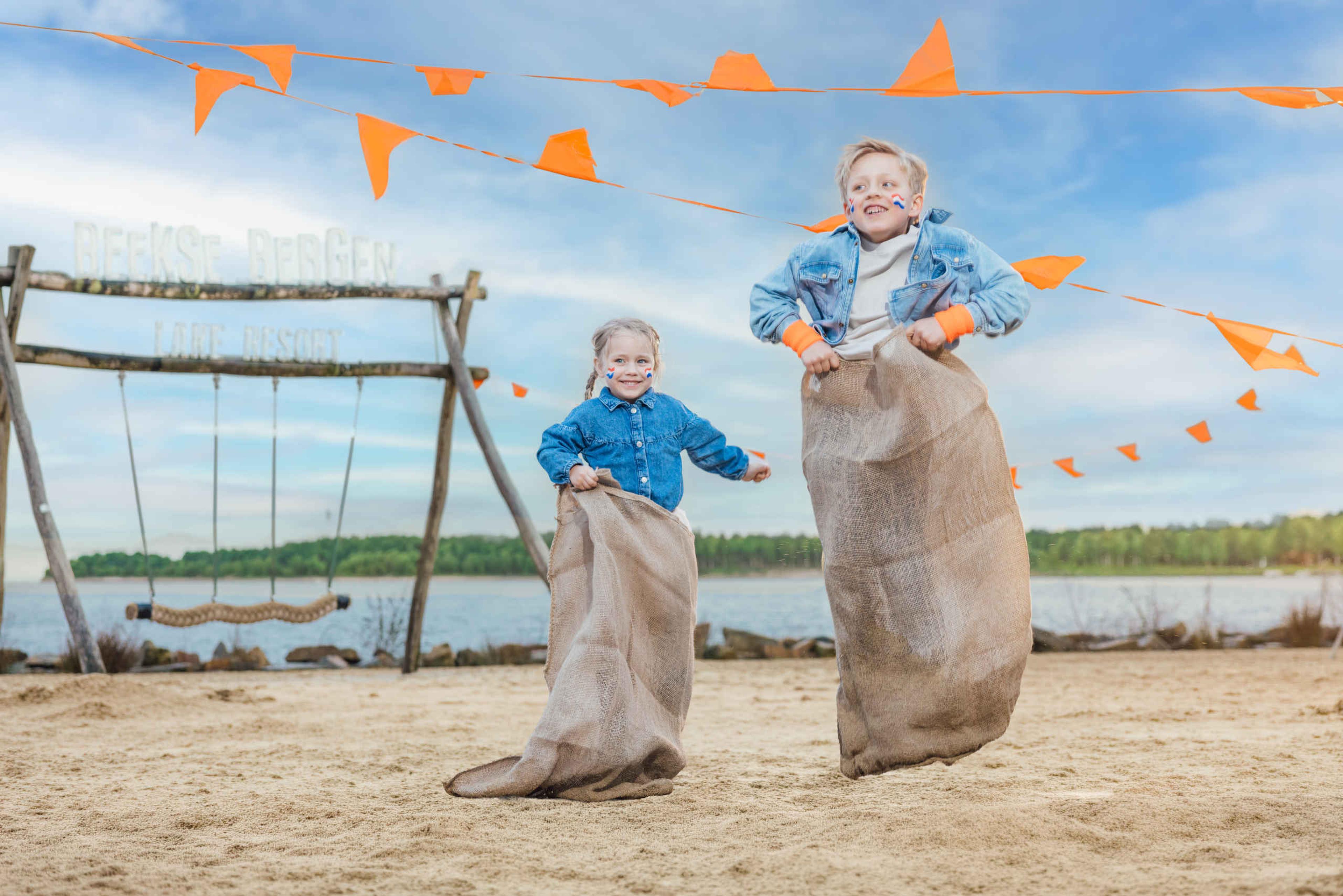 Twee kinderen zijn aan het zaklopen bij de Koningsspelen op Lake Resort Beekse Bergen.