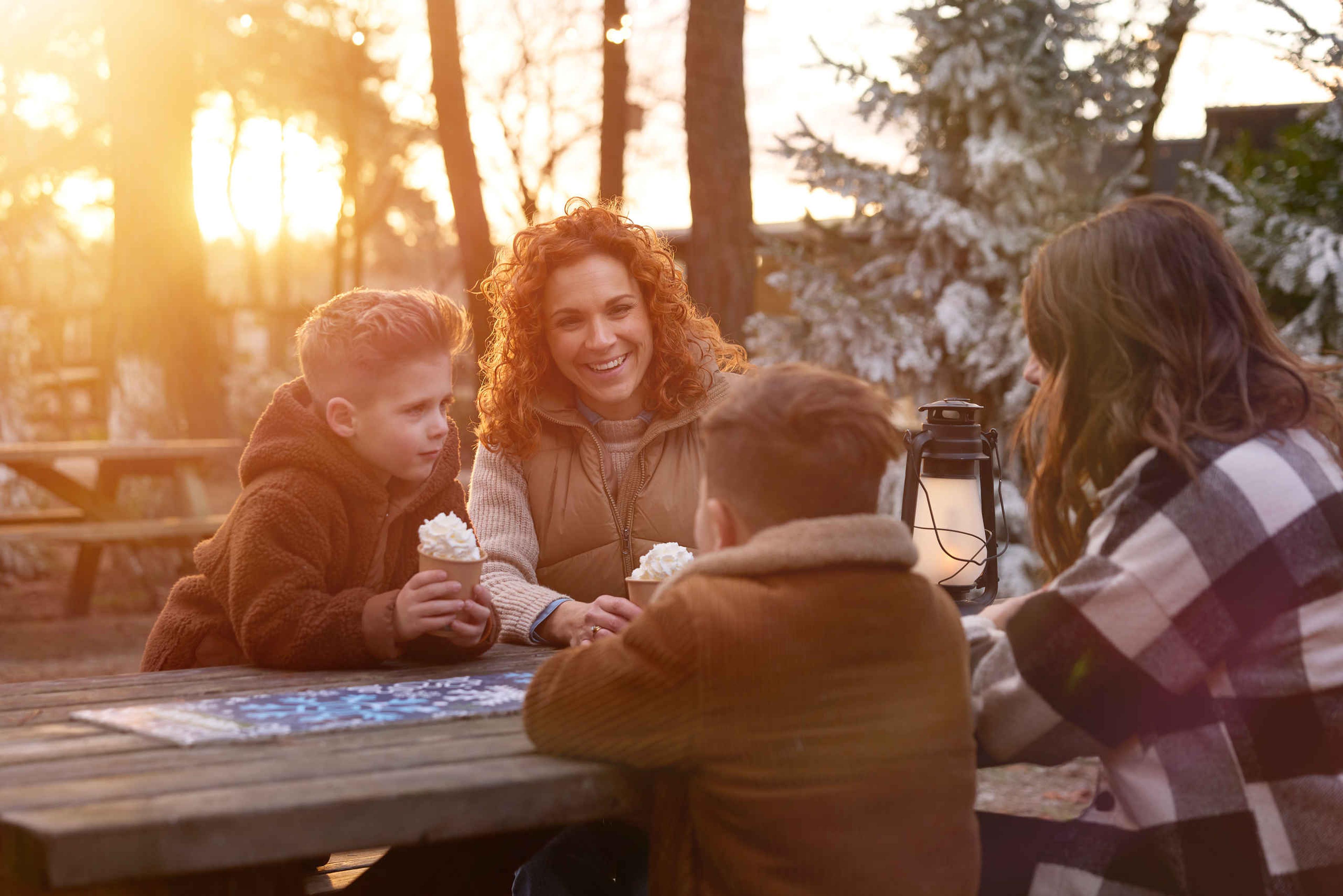 Twee vrouwen en kinderen zitten op het winterplein bij Safaripark Beekse Bergen