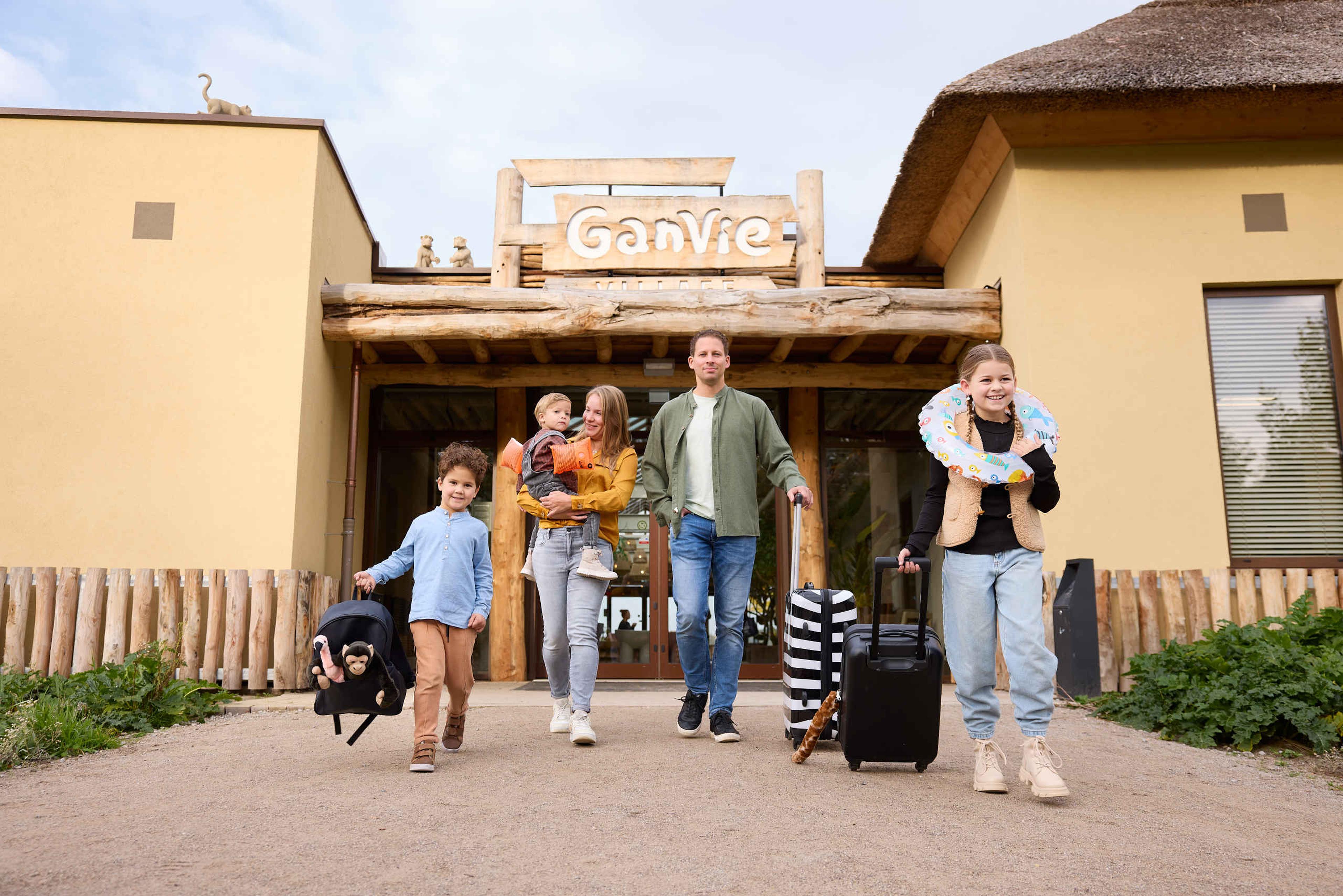 Gezin met kinderen knuffels koffers voor Ganvie village op Lake Resort Beekse Bergen