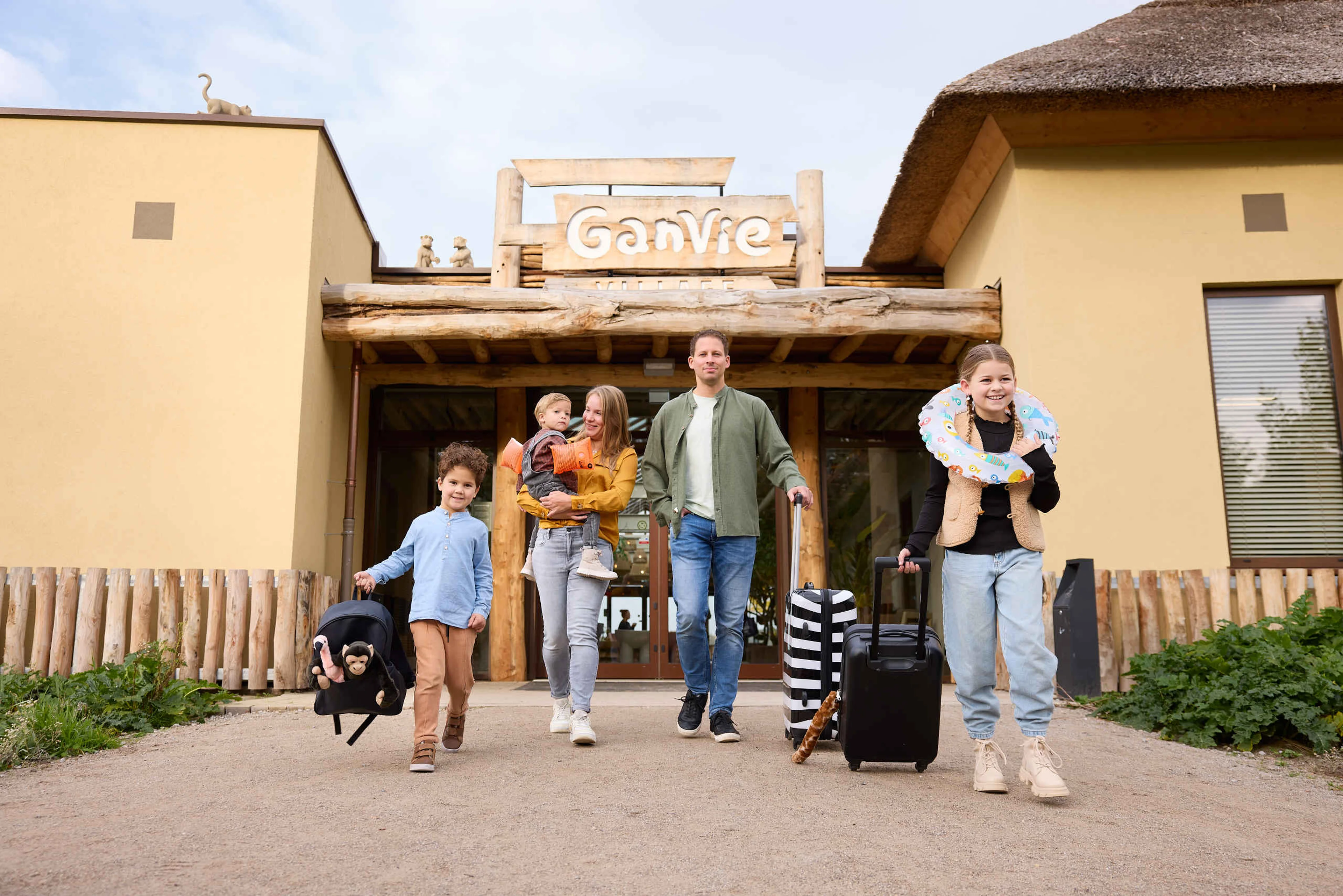 Gezin met kinderen knuffels koffers voor Ganvie village op Lake Resort Beekse Bergen
