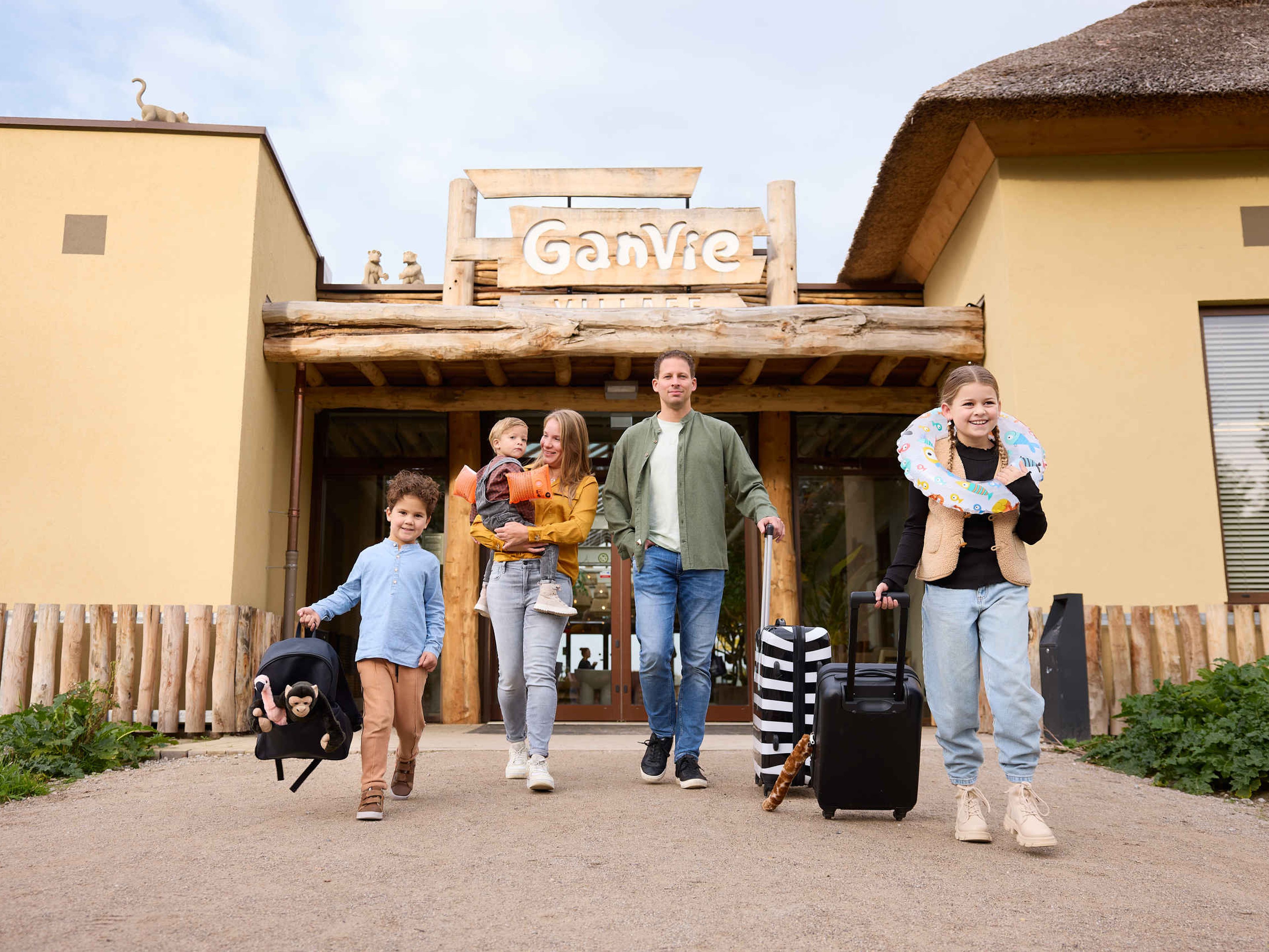 Gezin met kinderen knuffels koffers voor Ganvie village op Lake Resort Beekse Bergen