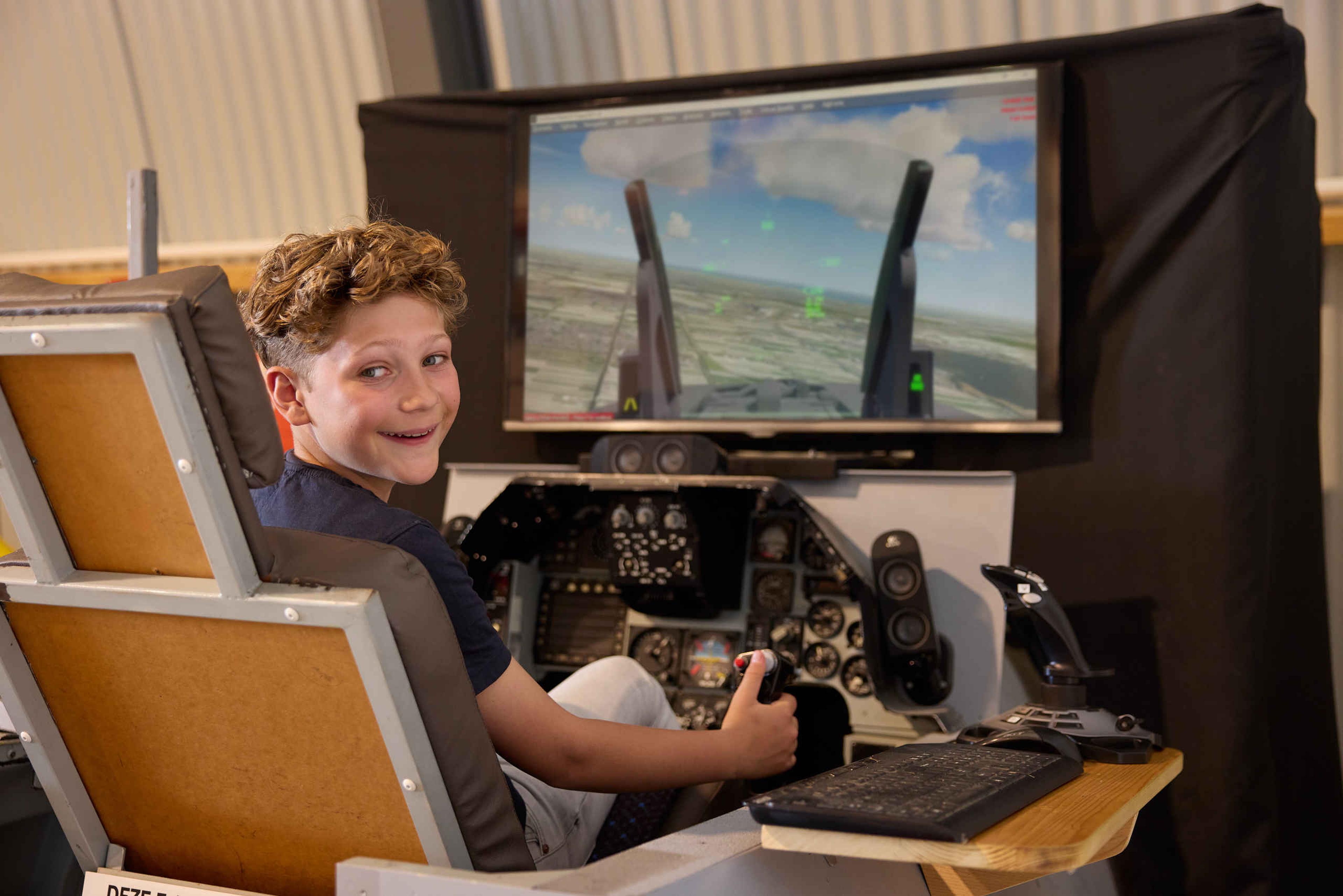 Kinderen vluchtsimulator jongen straaljagerexpositie Luchtvaartmuseum Aviodrome