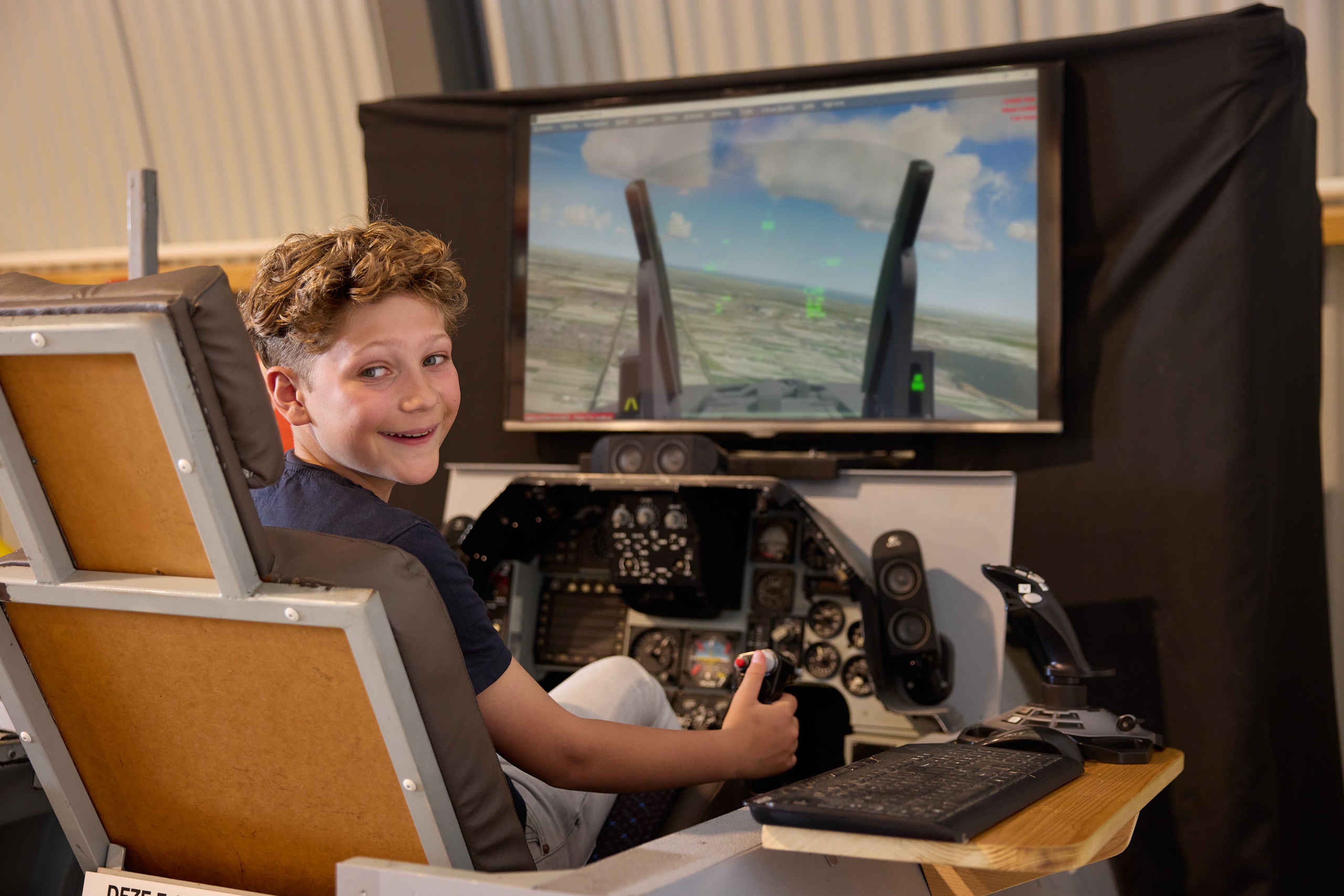 Kinderen vluchtsimulator jongen straaljagerexpositie Luchtvaartmuseum Aviodrome