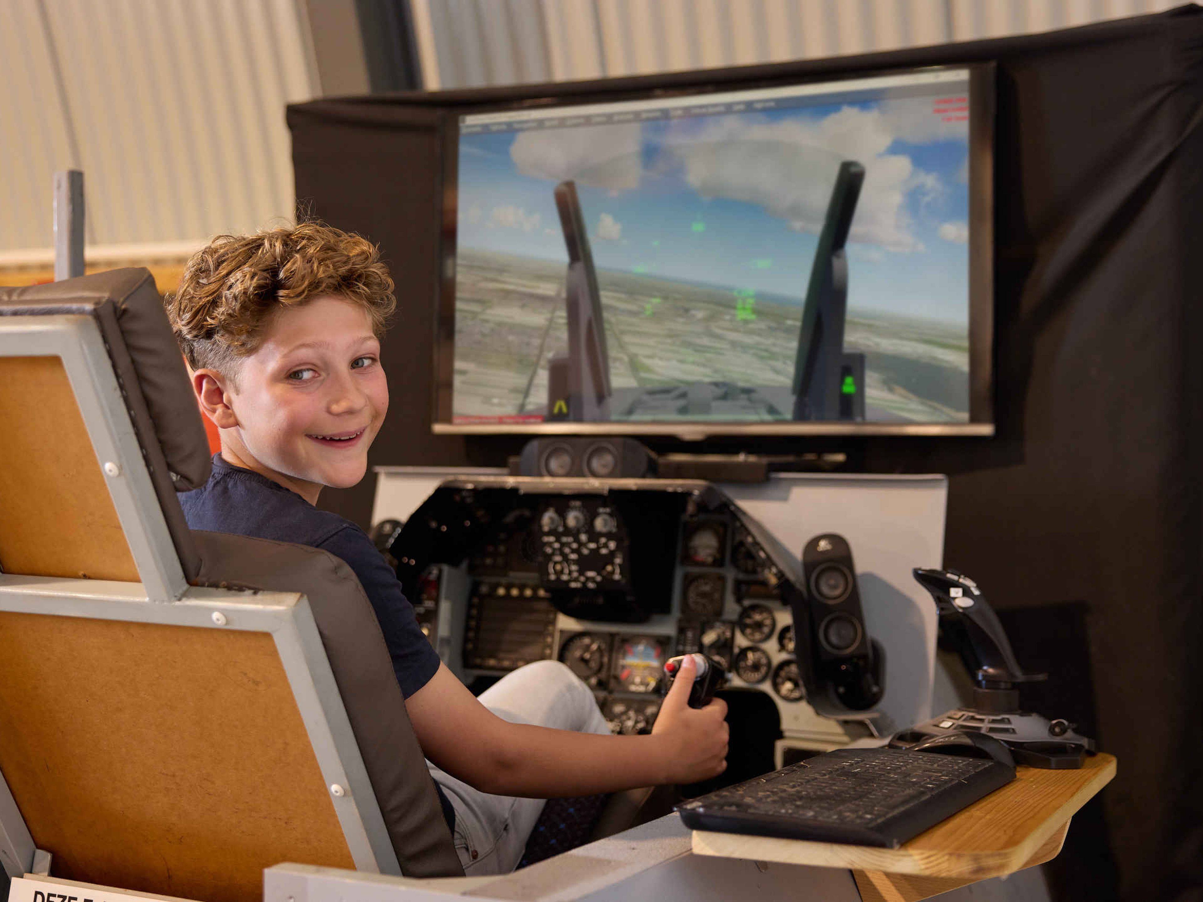Kinderen vluchtsimulator jongen straaljagerexpositie Luchtvaartmuseum Aviodrome