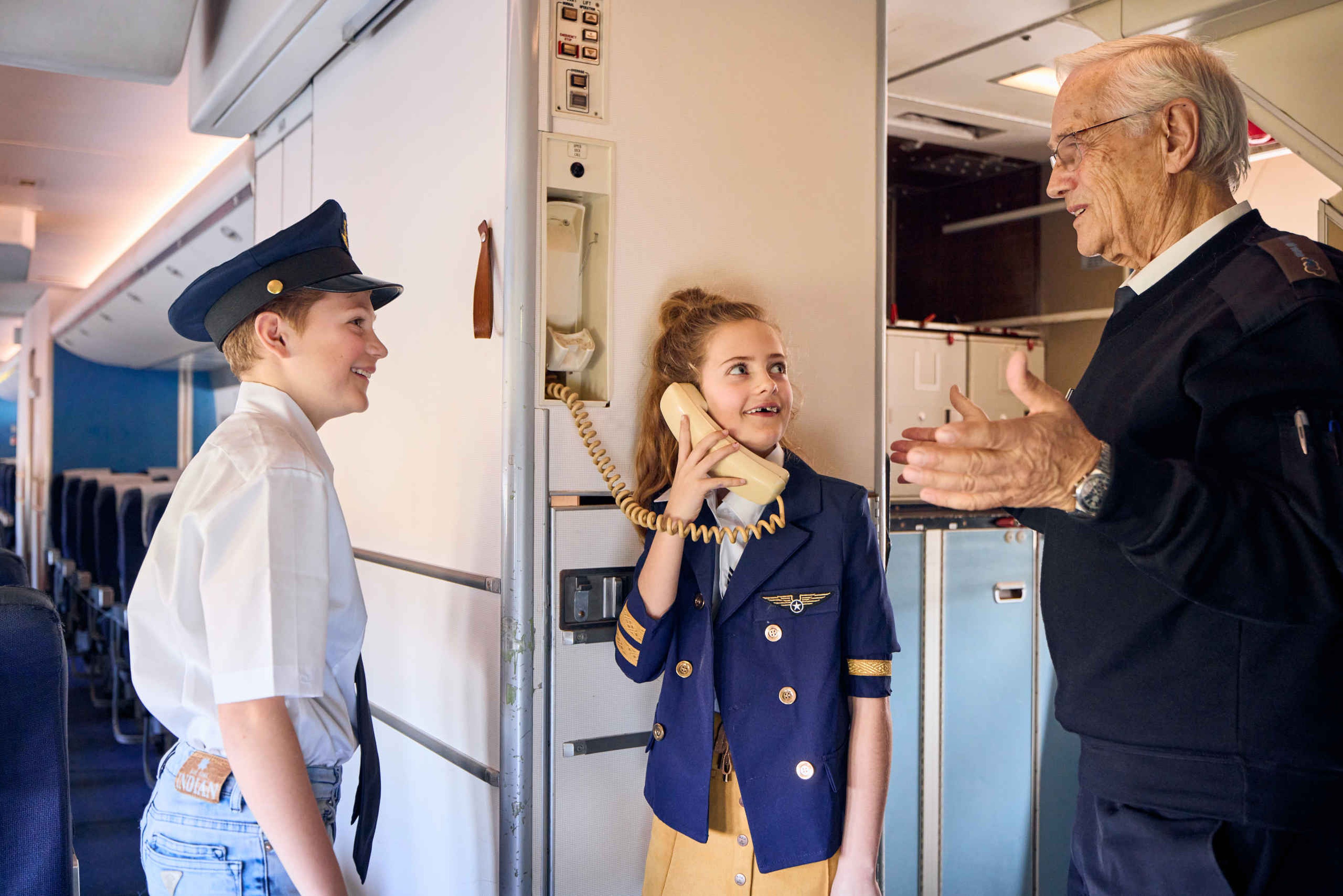 Kinderen krijgen uitleg van een vrijwilliger over het omroepen bij Luchtvaartmuseum Aviodrome