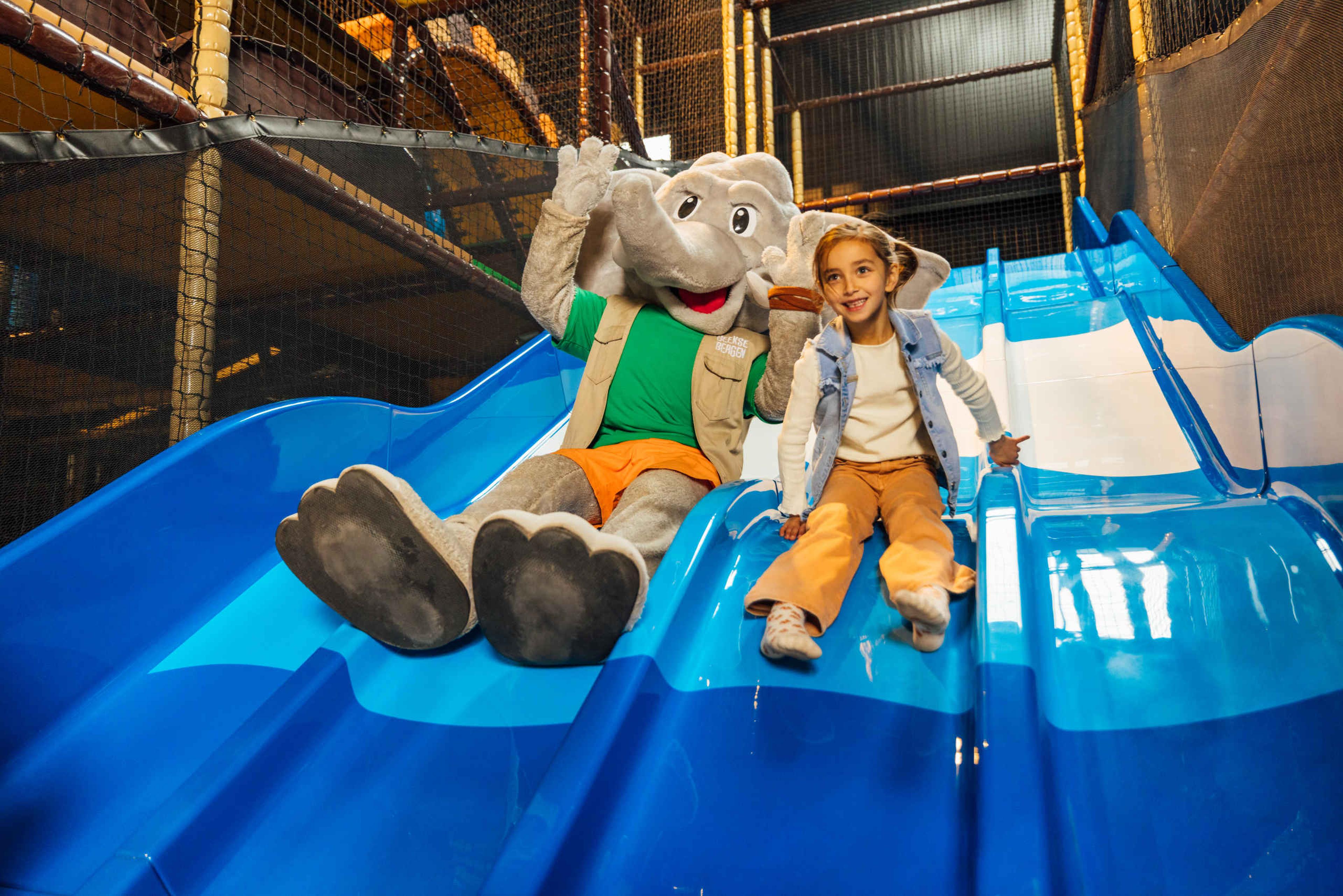 Djambo en meisje op de glijbaan van Speelland Indoor