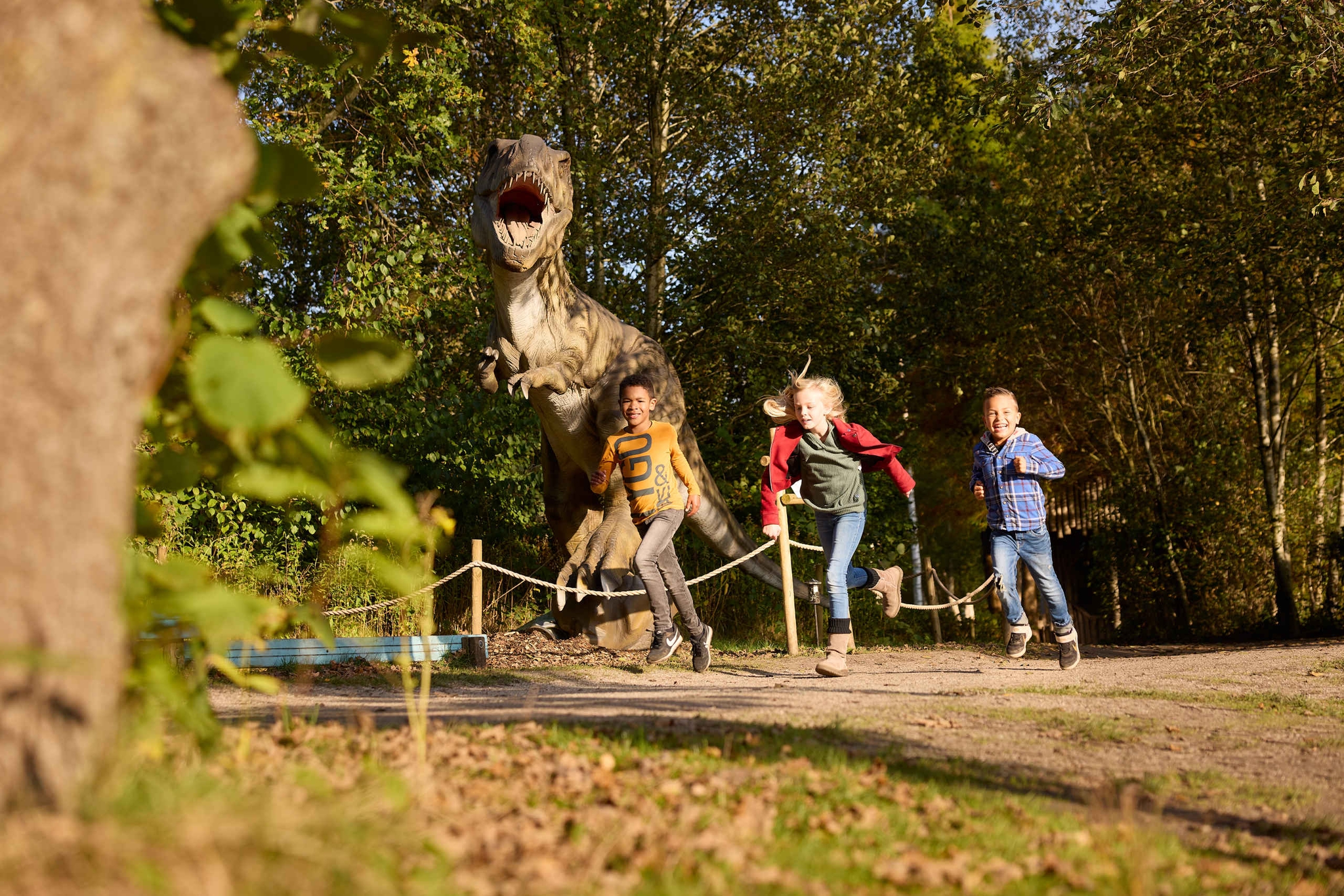 Kinderen rennen langs dino tijdens kinderfeest Dino Weken AquaZoo Leeuwarden