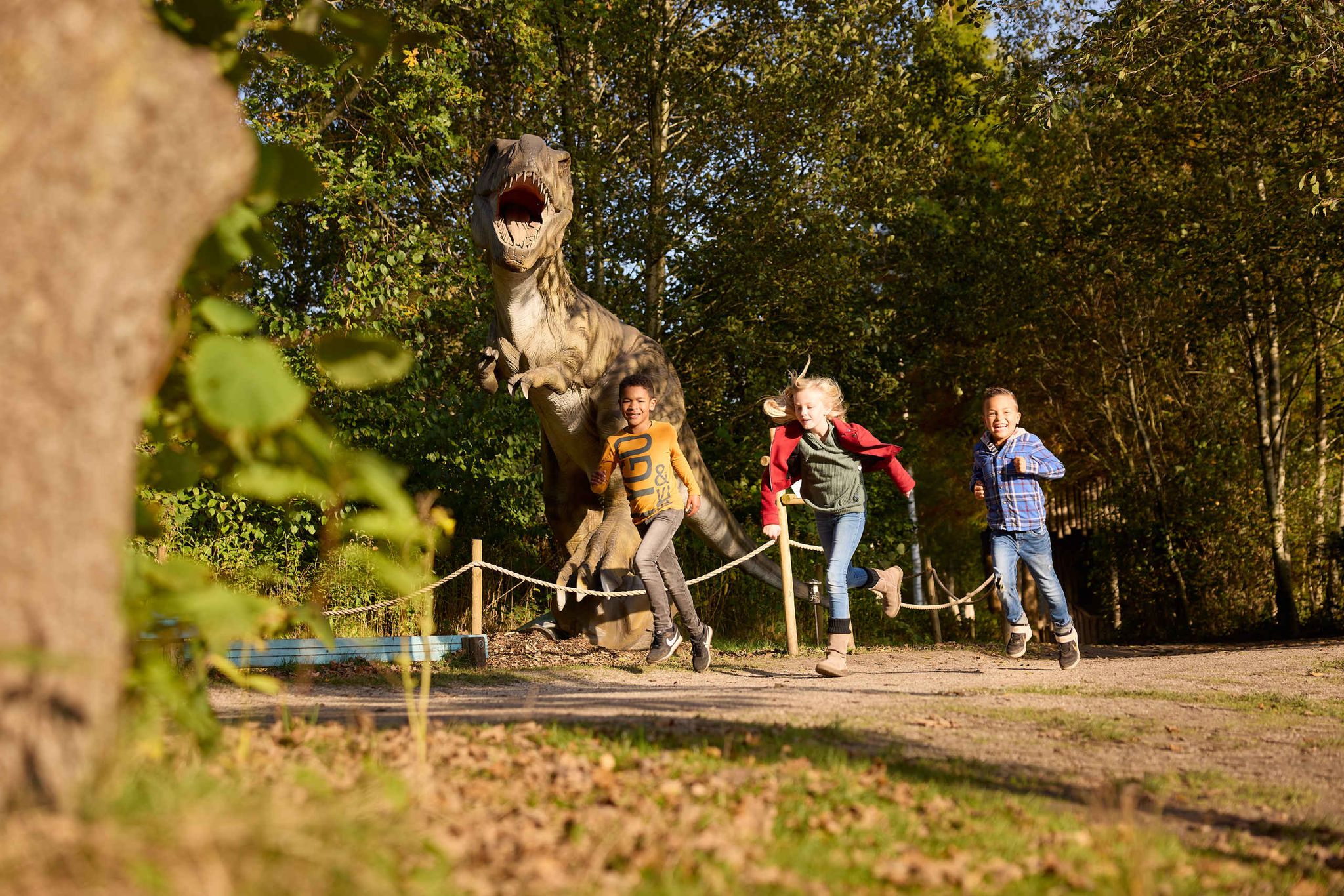 Kinderen rennen langs dino tijdens kinderfeest Dino Weken AquaZoo Leeuwarden