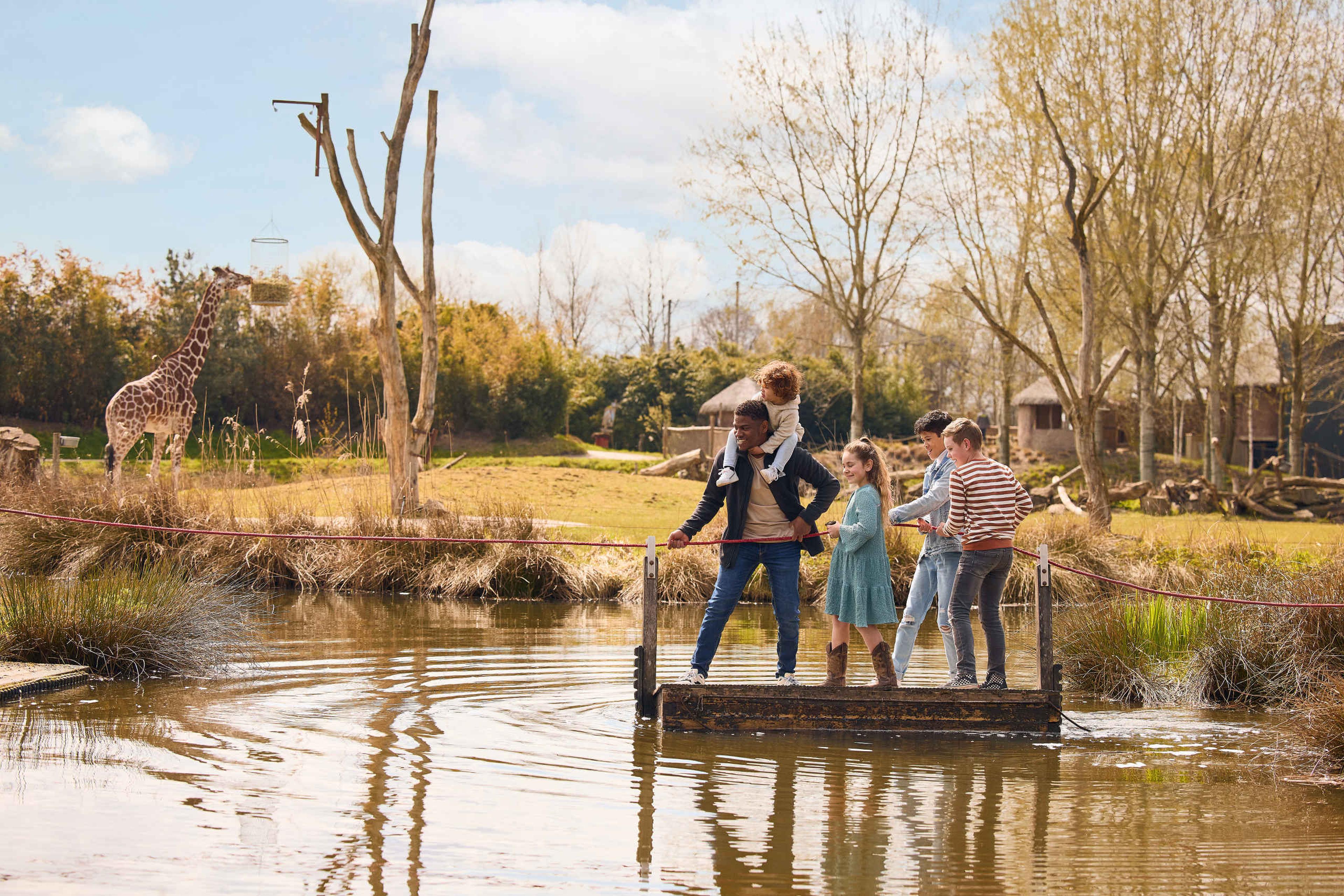 Gezin op een vlot bij de giraffen in ZooParc Overloon