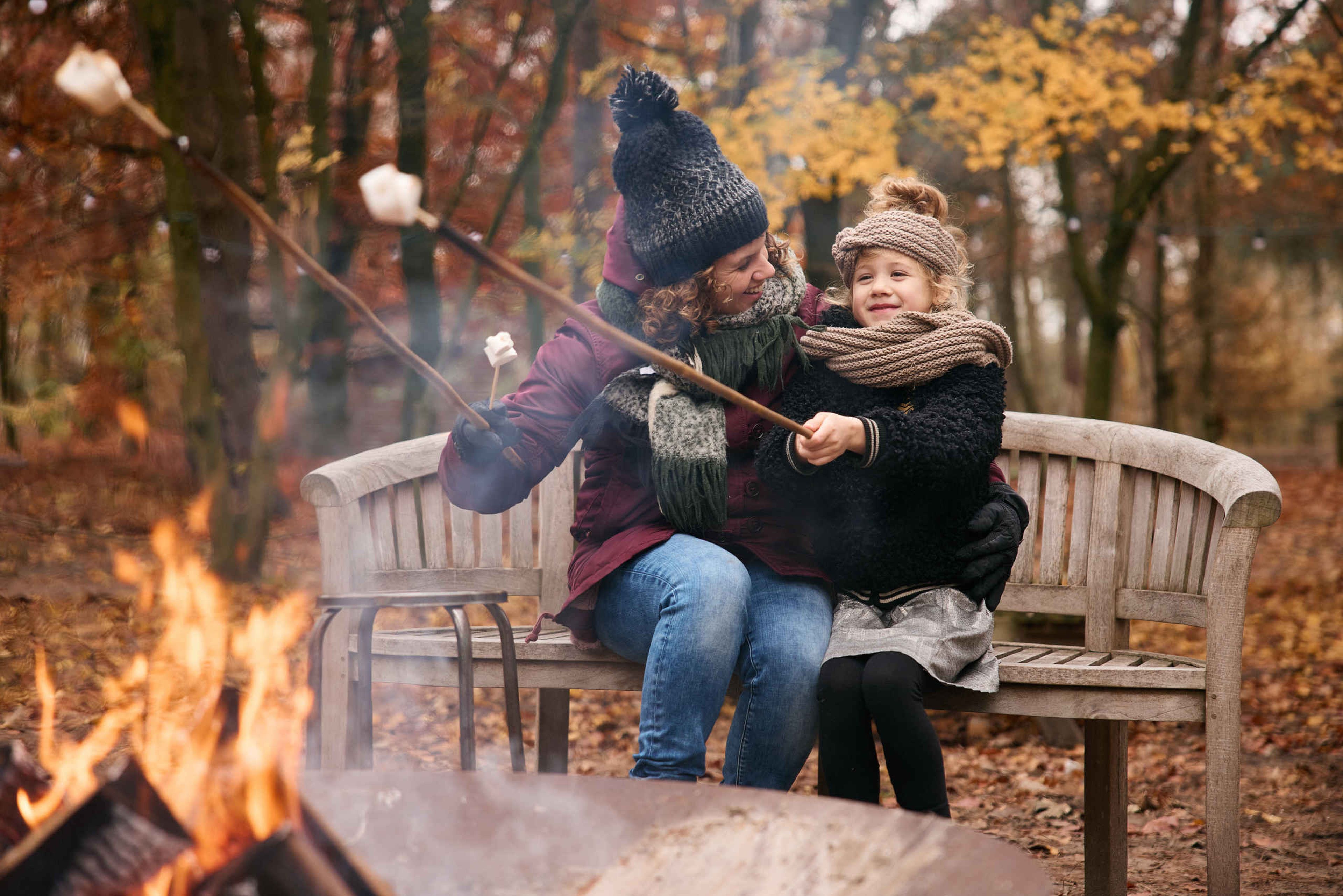 Moeder en kind roosteren marshmallows bij een kampvuur in Beekse Bergen