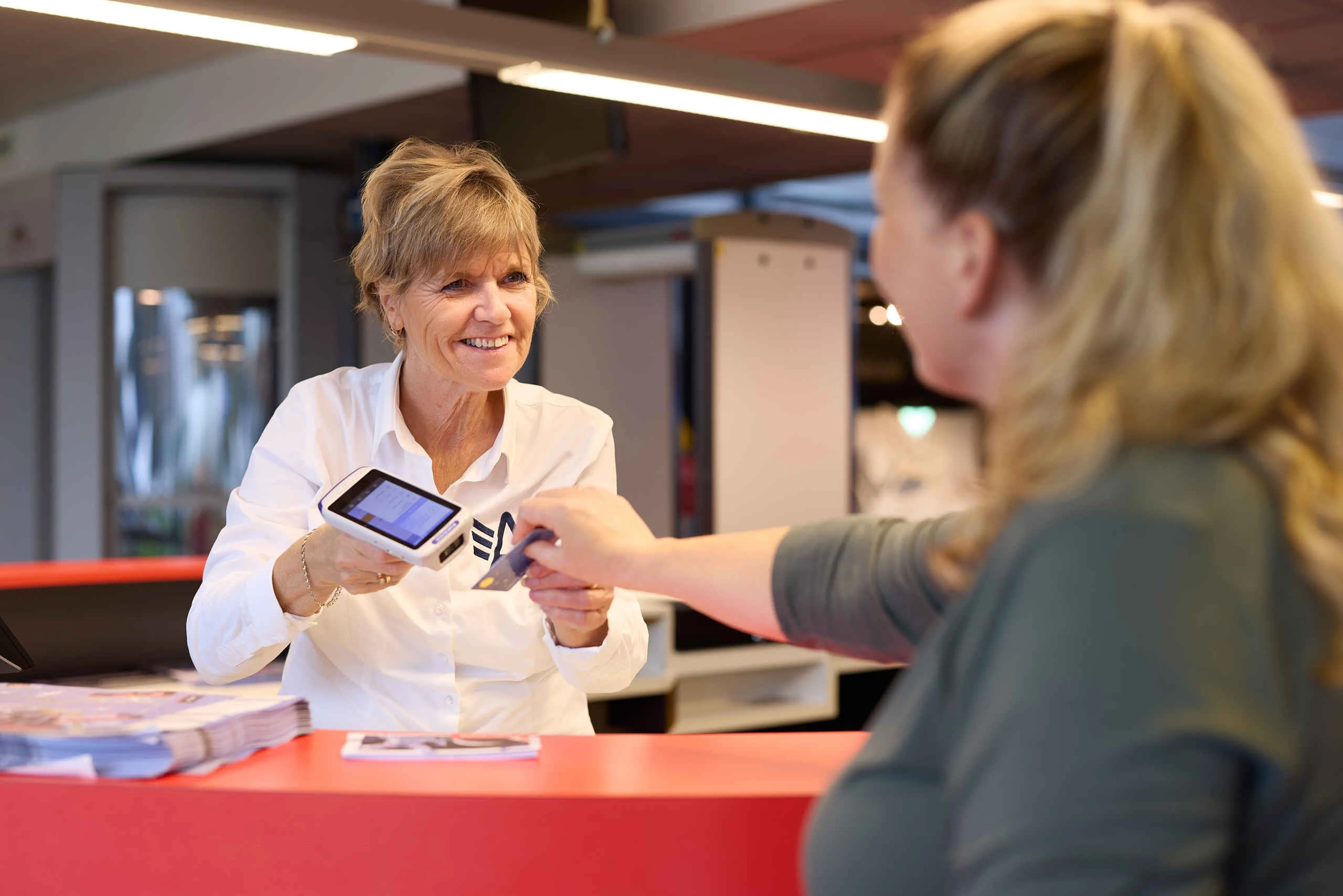 Receptie medewerker helpt een gast bij Luchtvaartmuseum Aviodrome