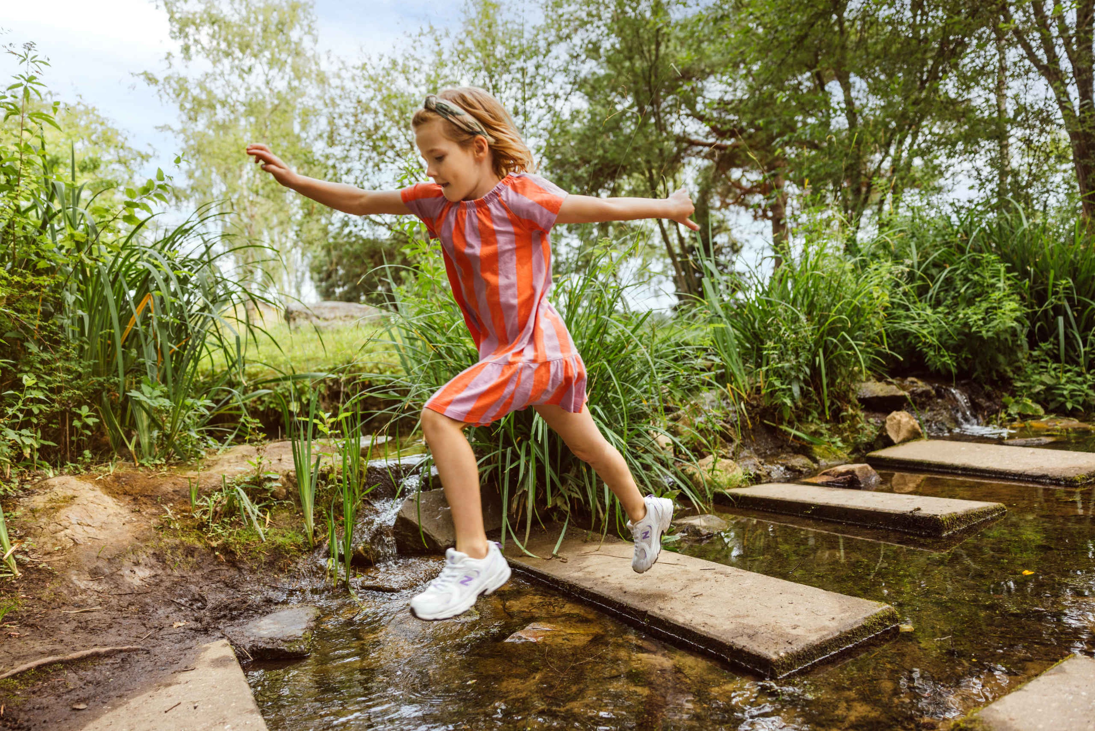In de zomer springt een meisje over de avonturenpaadjes in Safaripark Beekse Bergen