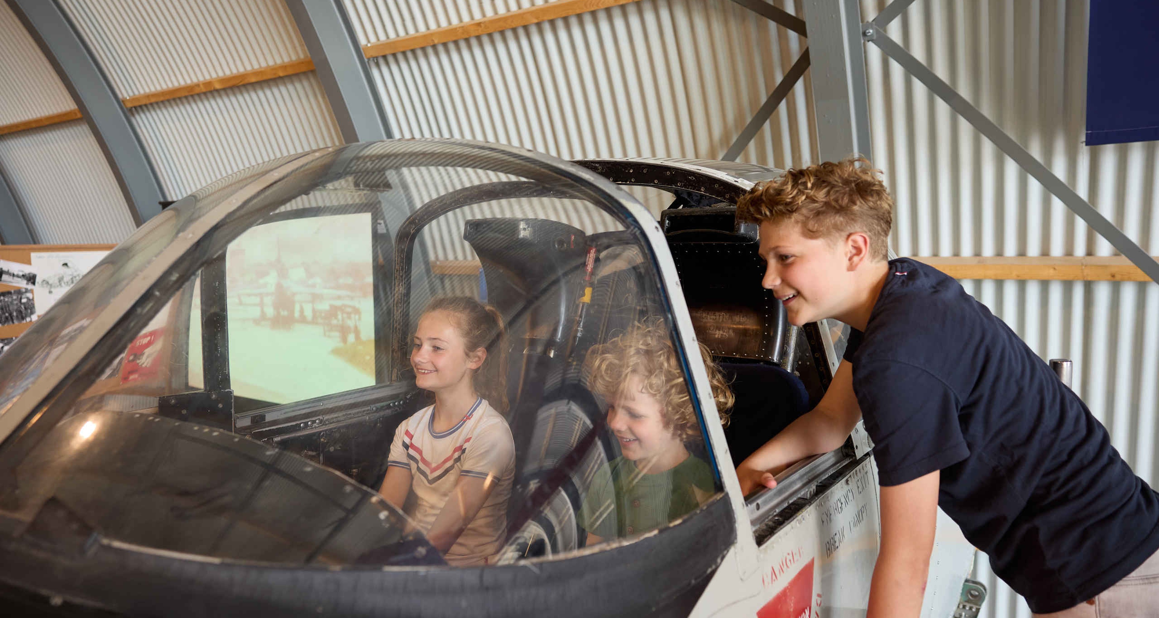 Kinderen in de cockpit tijdens de straaljagerexpositie in Luchtvaartmuseum Aviodrome