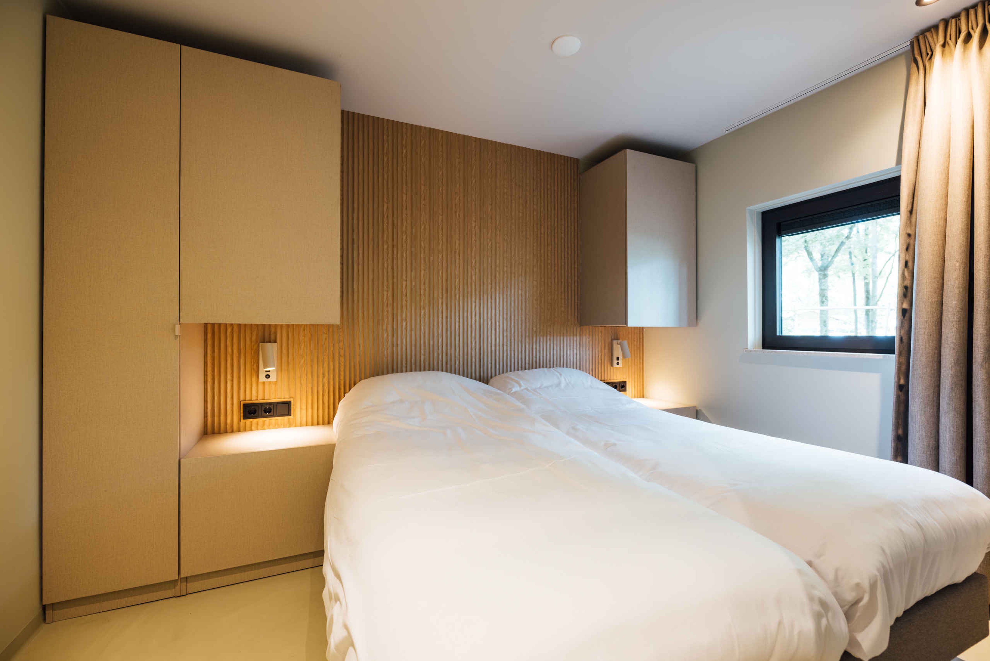 De slaapkamer met het tweepersoonsbed in de Forest Jungalow op Lake Resort Beekse Bergen.