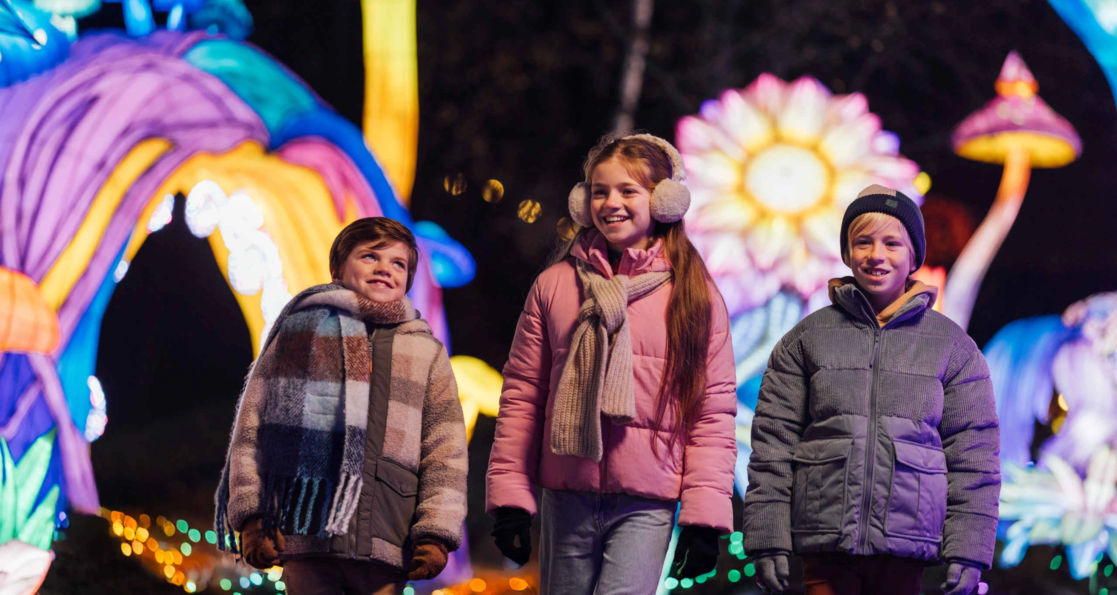 Kinderen wandelen tussen de lichtfiguren tijdens Light Safari Beekse Bergen