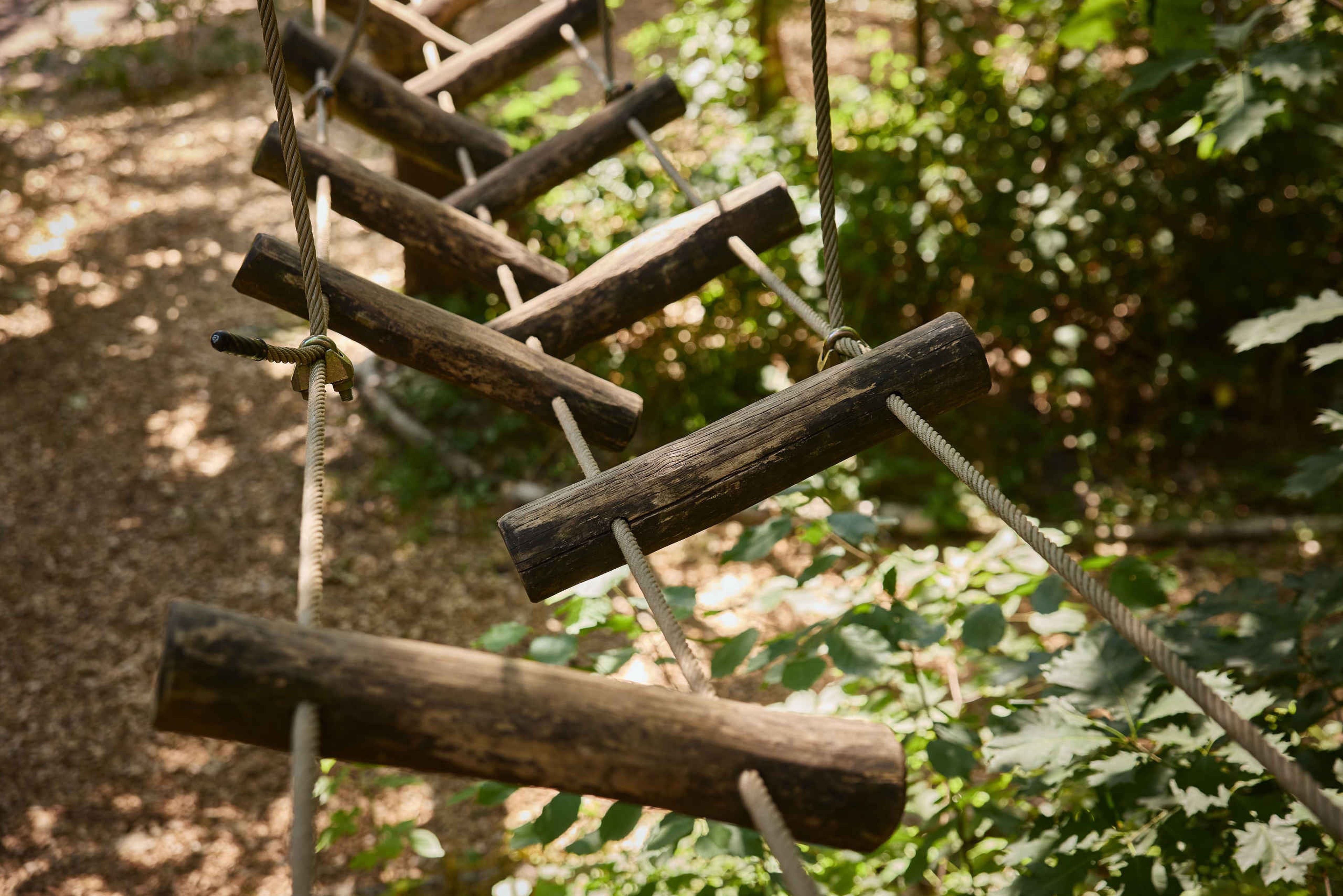 Een houten balkenbrugop route 2 van het klimparcours bij Klimrijk Brabant