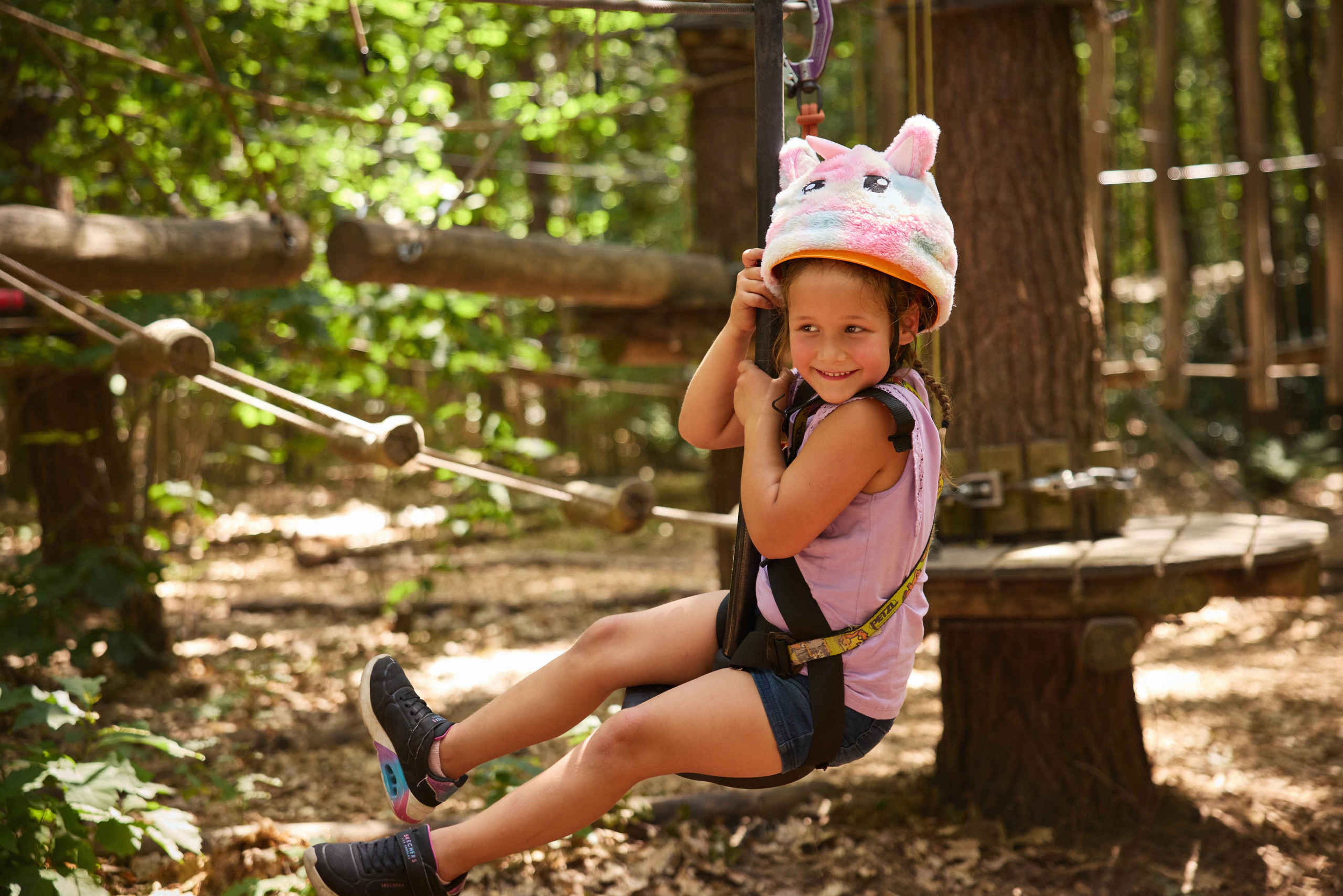 Een meisje op het pico parcours met een speciale verjaardagsmuts bij Klimrijk Brabant