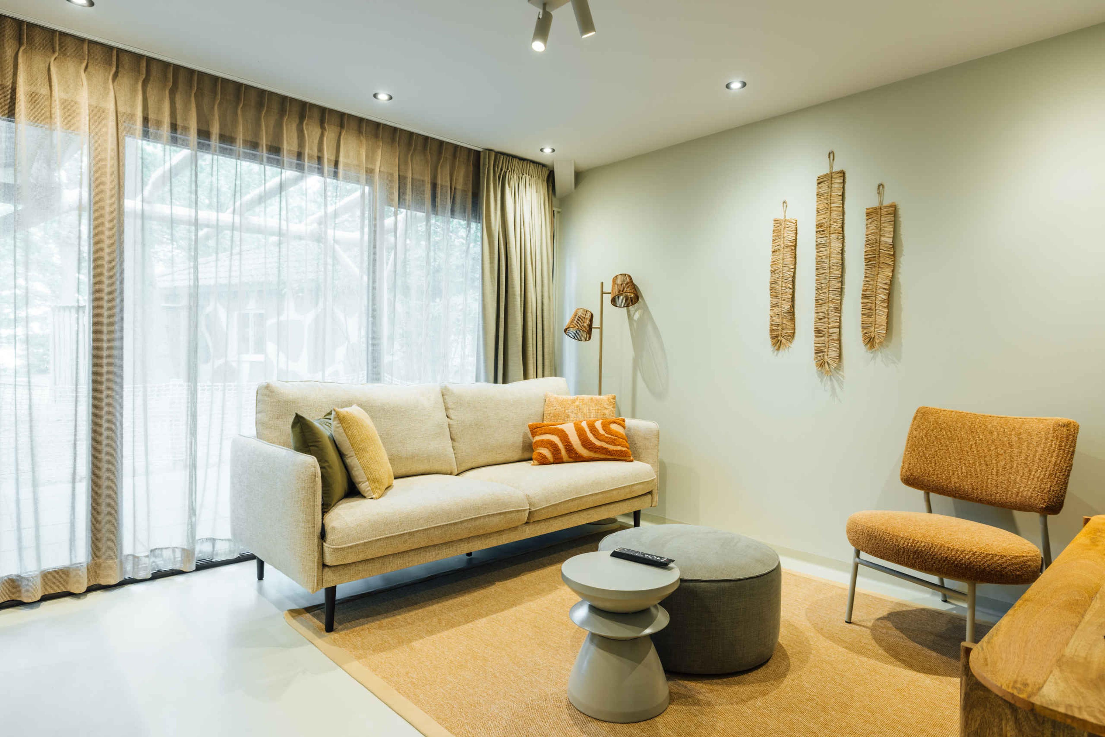 De woonkamer met een bankstel en stoel in de Forest Jungalow op Lake Resort Beekse Bergen.