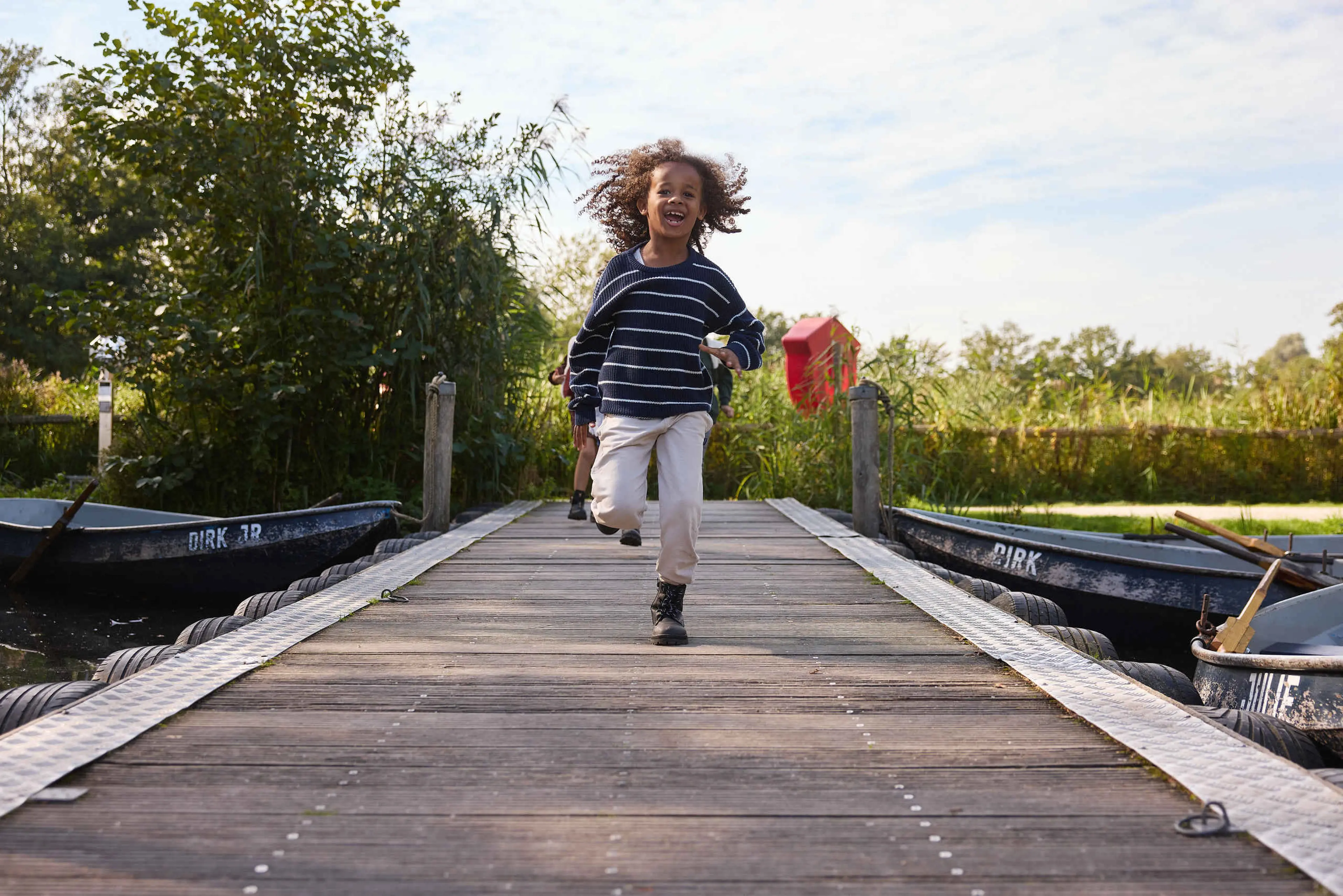 Jongen rent op vlonder langs kano's AquaZoo Leeuwarden