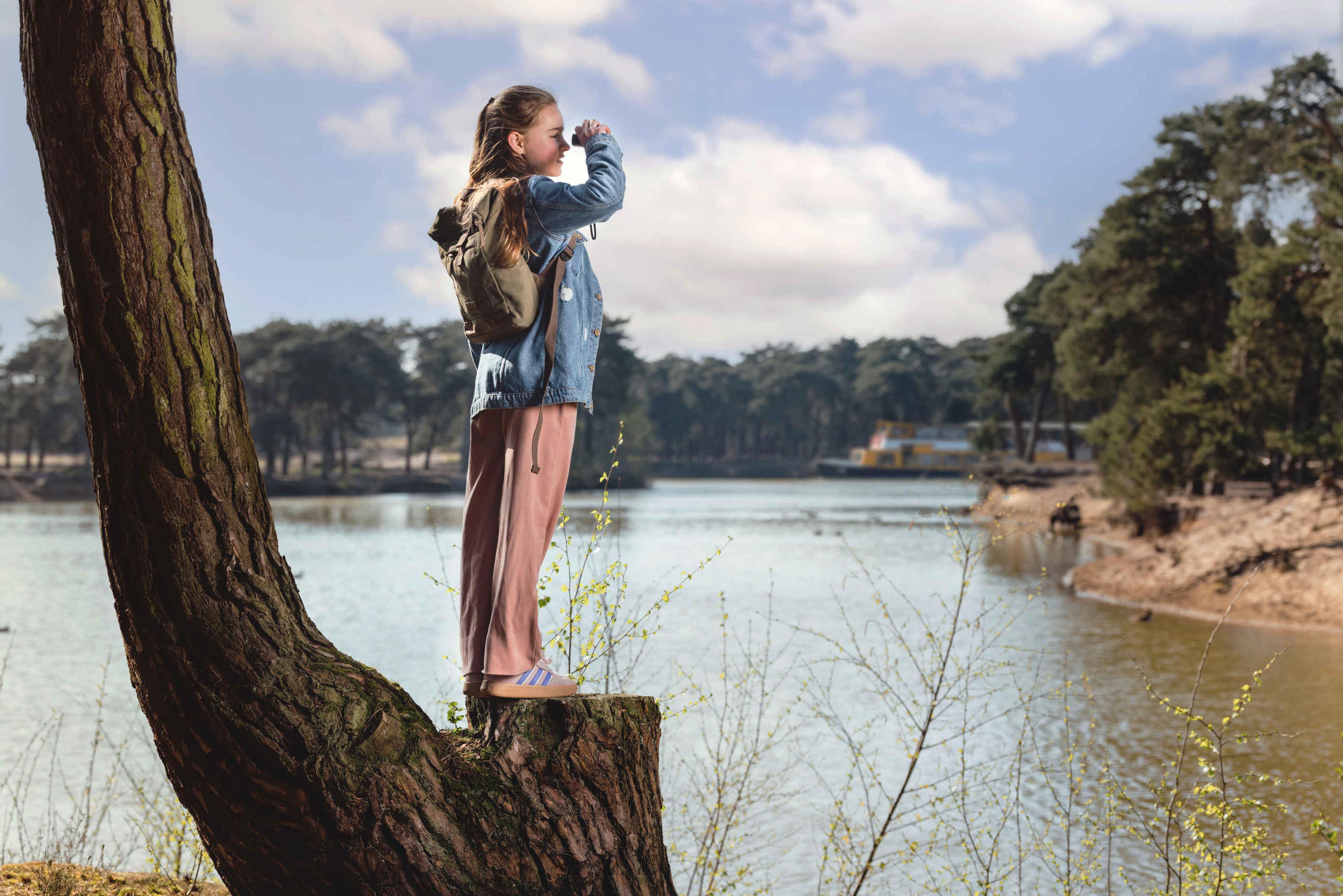 Wandelsafari meisje met verrekijker in boom in Safaripark Beekse Bergen