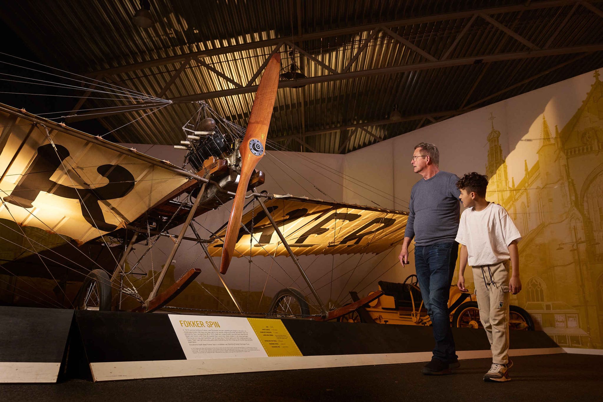Een man en kind lopen door de binnenexpositie van Aviodrome