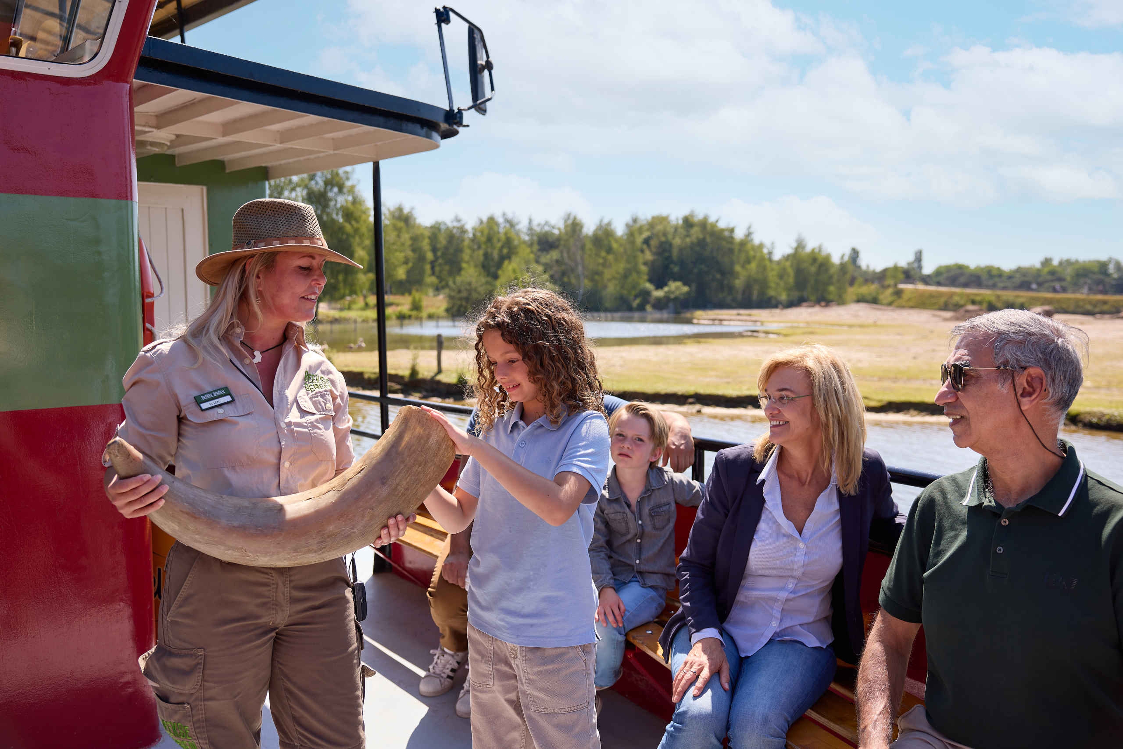 Ranger geeft uitleg aan gezin tijdens bootsafari in Safaripark Beekse Bergen