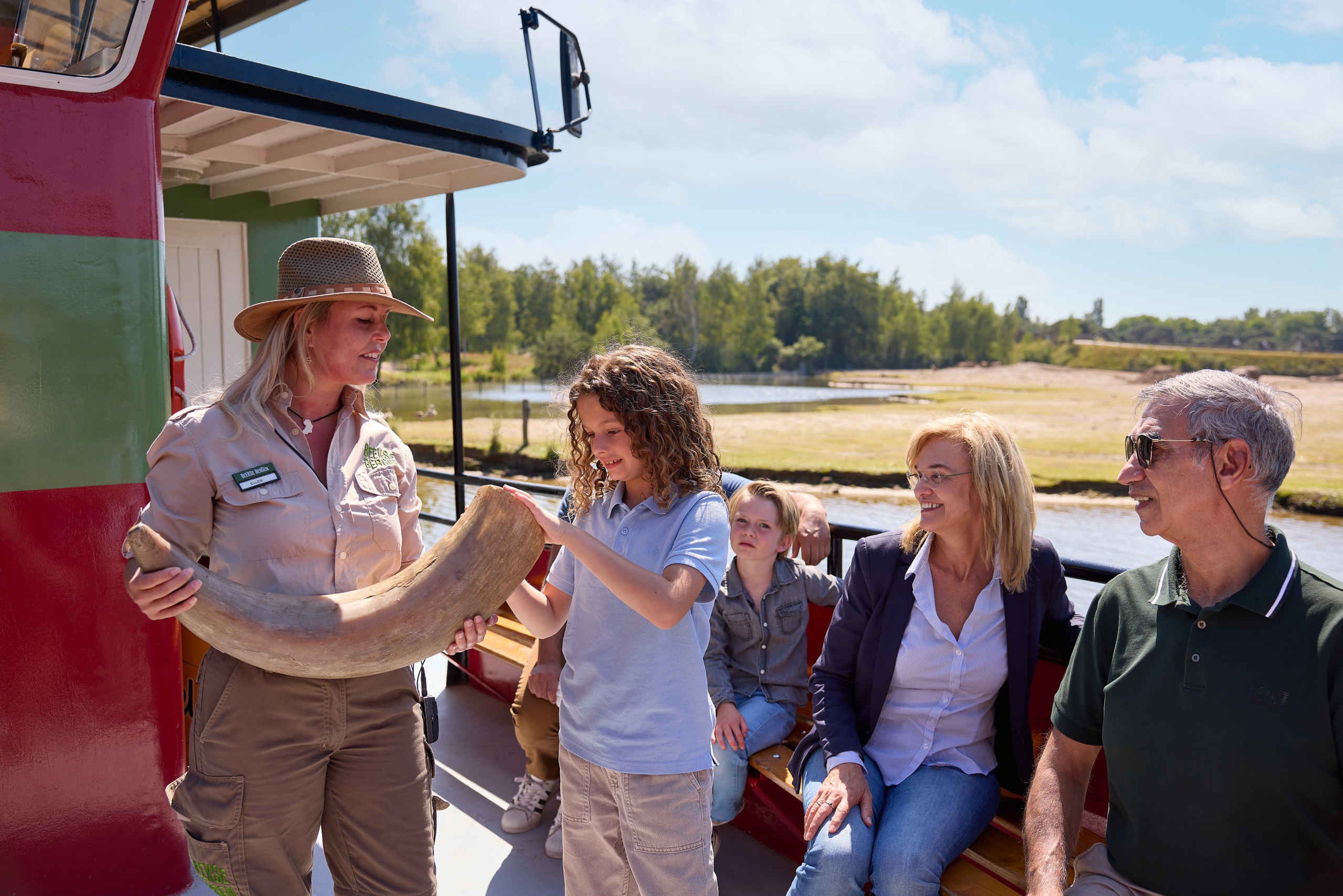 Ranger geeft uitleg aan gezin tijdens bootsafari in Safaripark Beekse Bergen