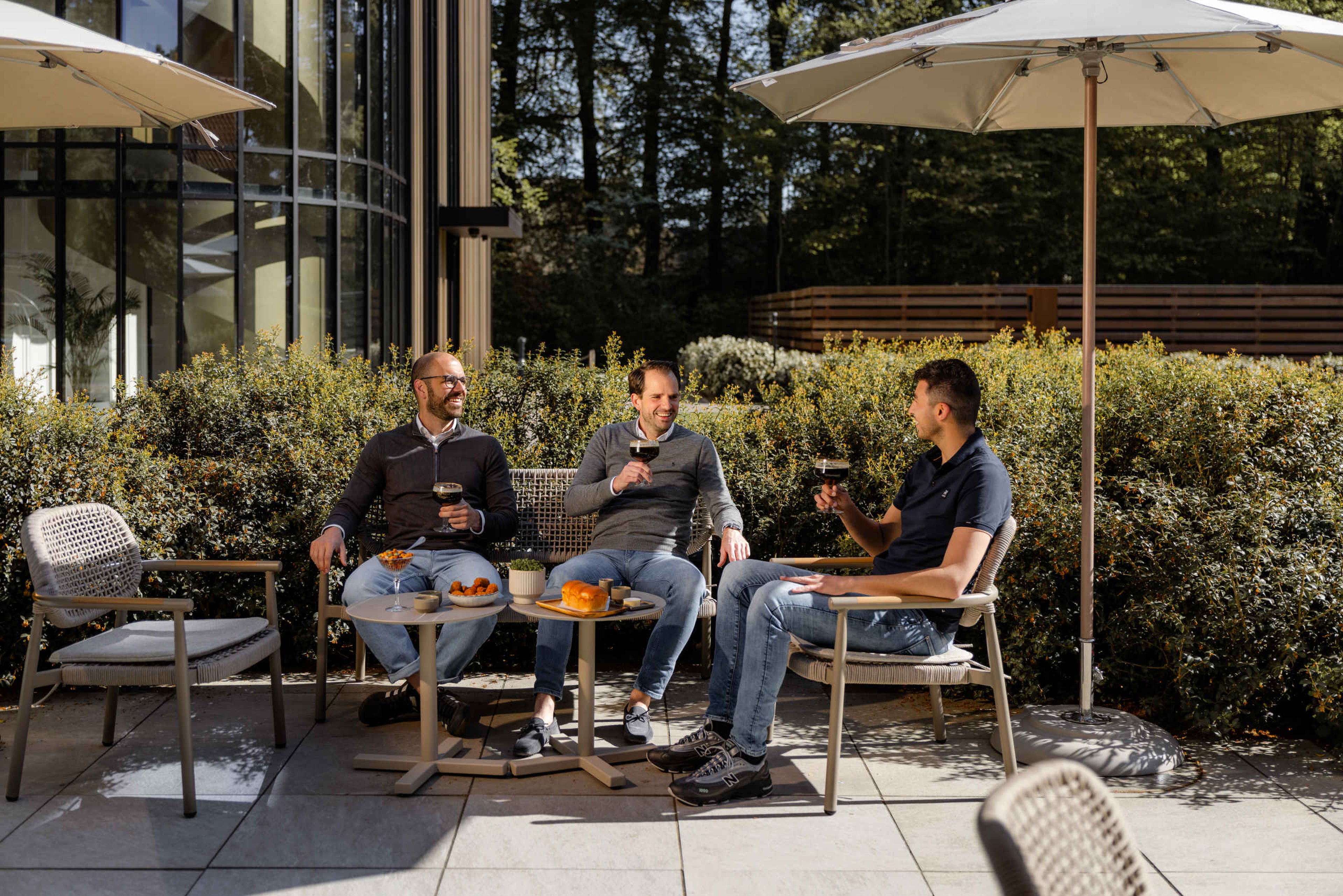 Mannen met bier op het terras van de Orangerie bij Kasteel Steenenburg