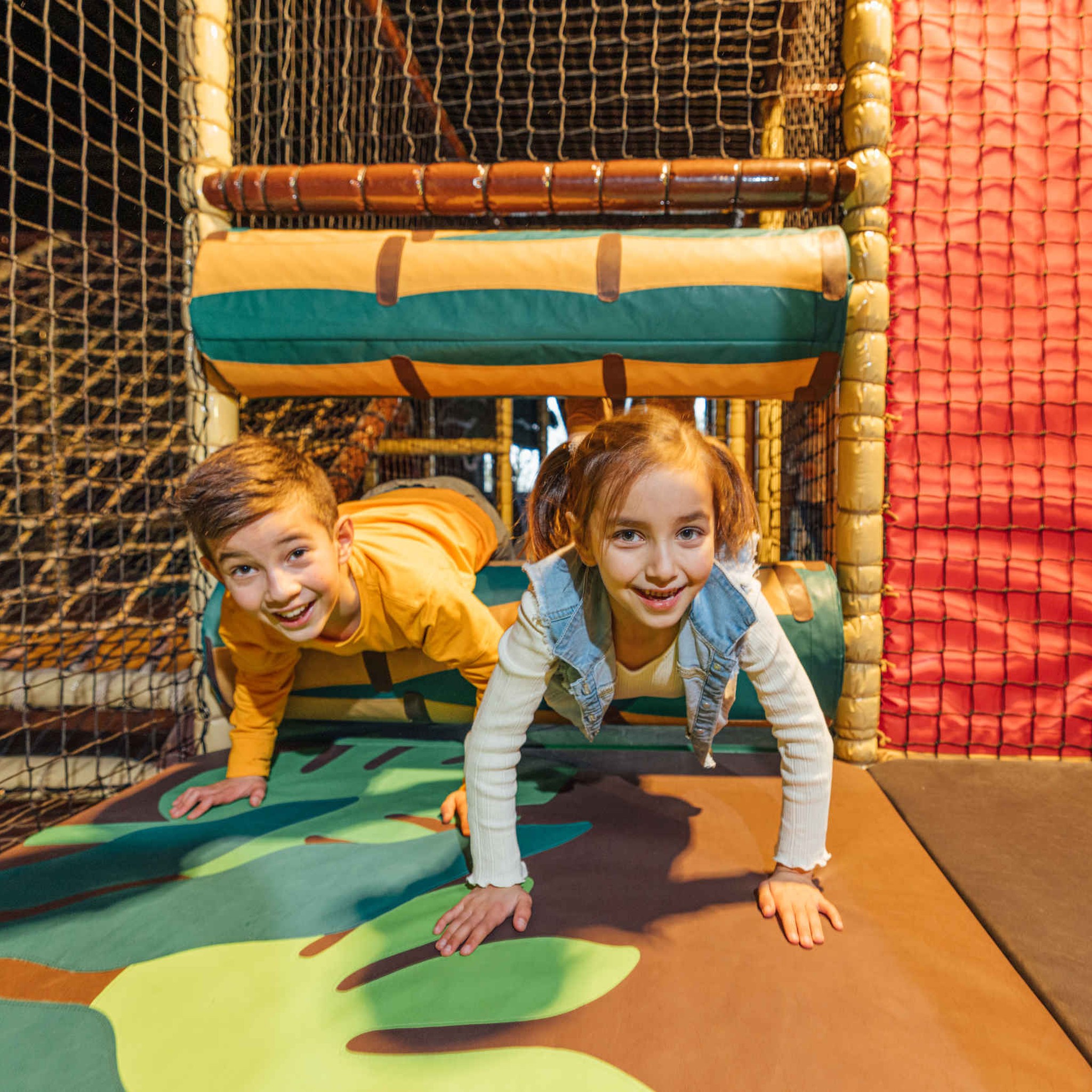 Twee kinderen spelen in een speeltoestel in Speelland Indoor Beekse Bergen.